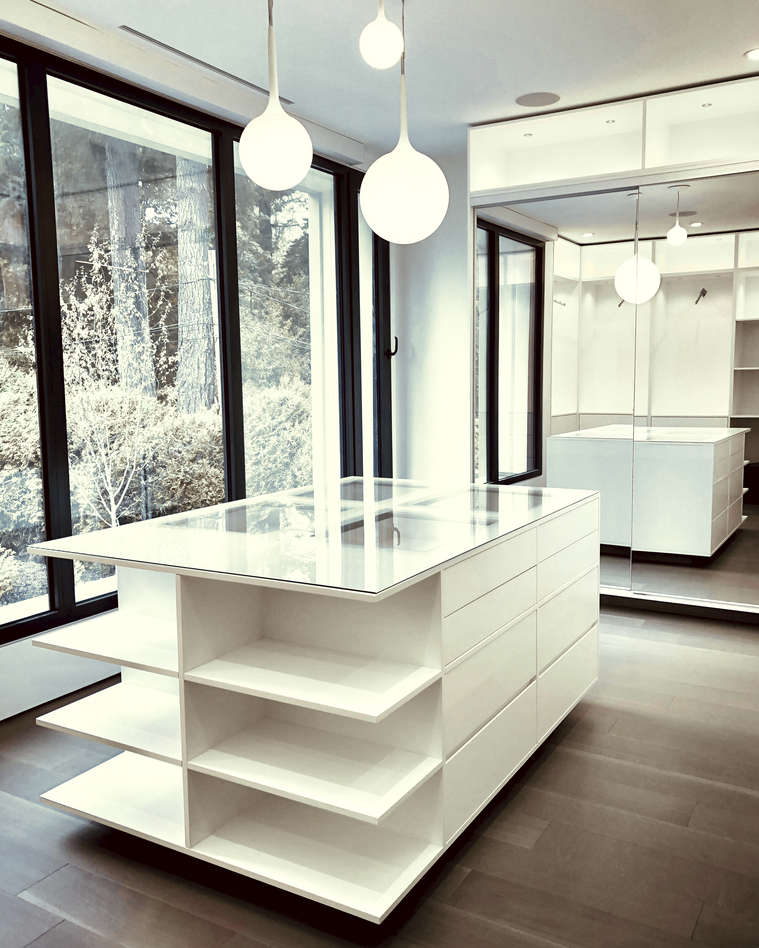 Prior fabrication experience.
White dressing room island with open shelving and drawers.