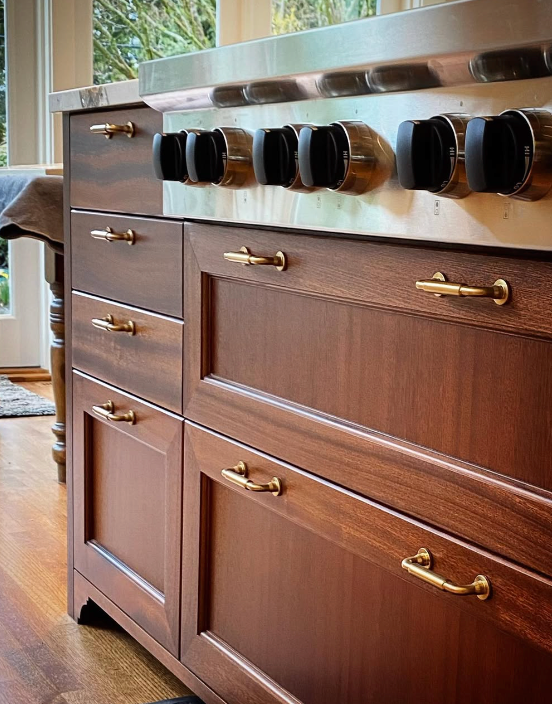 Prior fabrication experience.
Mahogany kitchen island with paneled cabinetry and brass hardware.