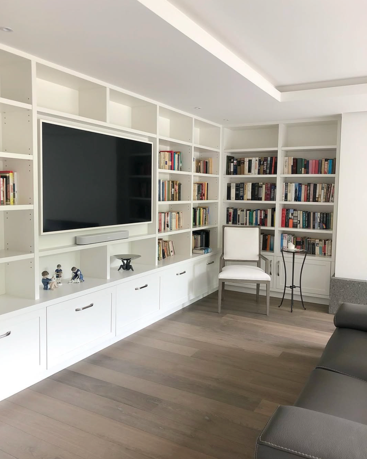 Prior fabrication experience.
White living room built-in with lower storage and an integrated television wall.