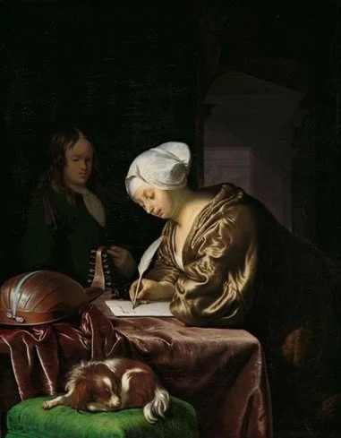 A woman in historical clothing and a white bonnet writing at a table, with a child in period clothing watching, and a sleeping dog on a green cushion nearby.