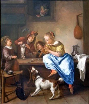 A woman reading to children around a table in a rustic room, with a dog standing nearby.