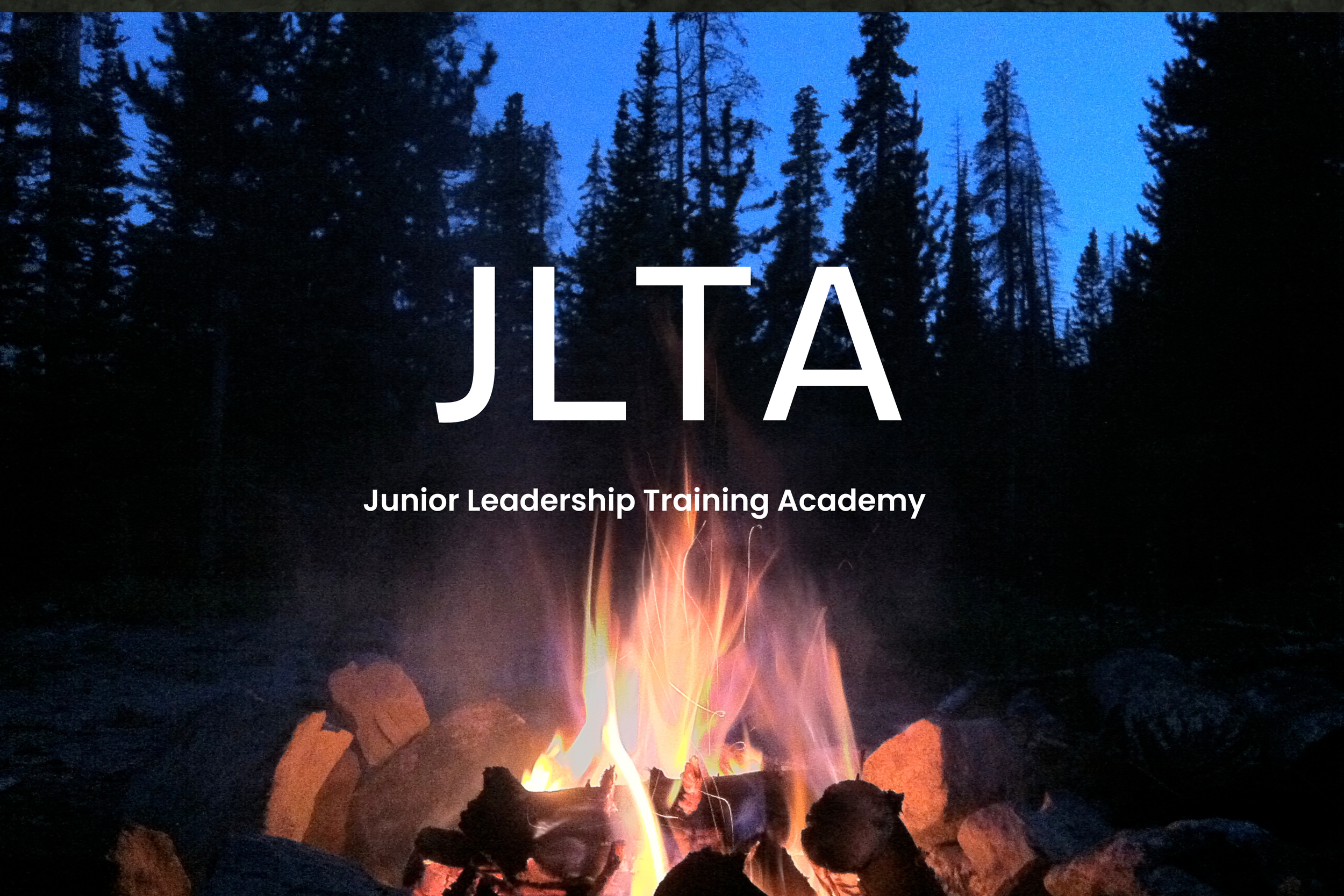 A campfire surrounded by rocks in a forested area at dusk, with tall pine trees and a blue sky in the background. The text 'JLT A' and 'Junior Leadership Training Academy' is overlaid on the image.