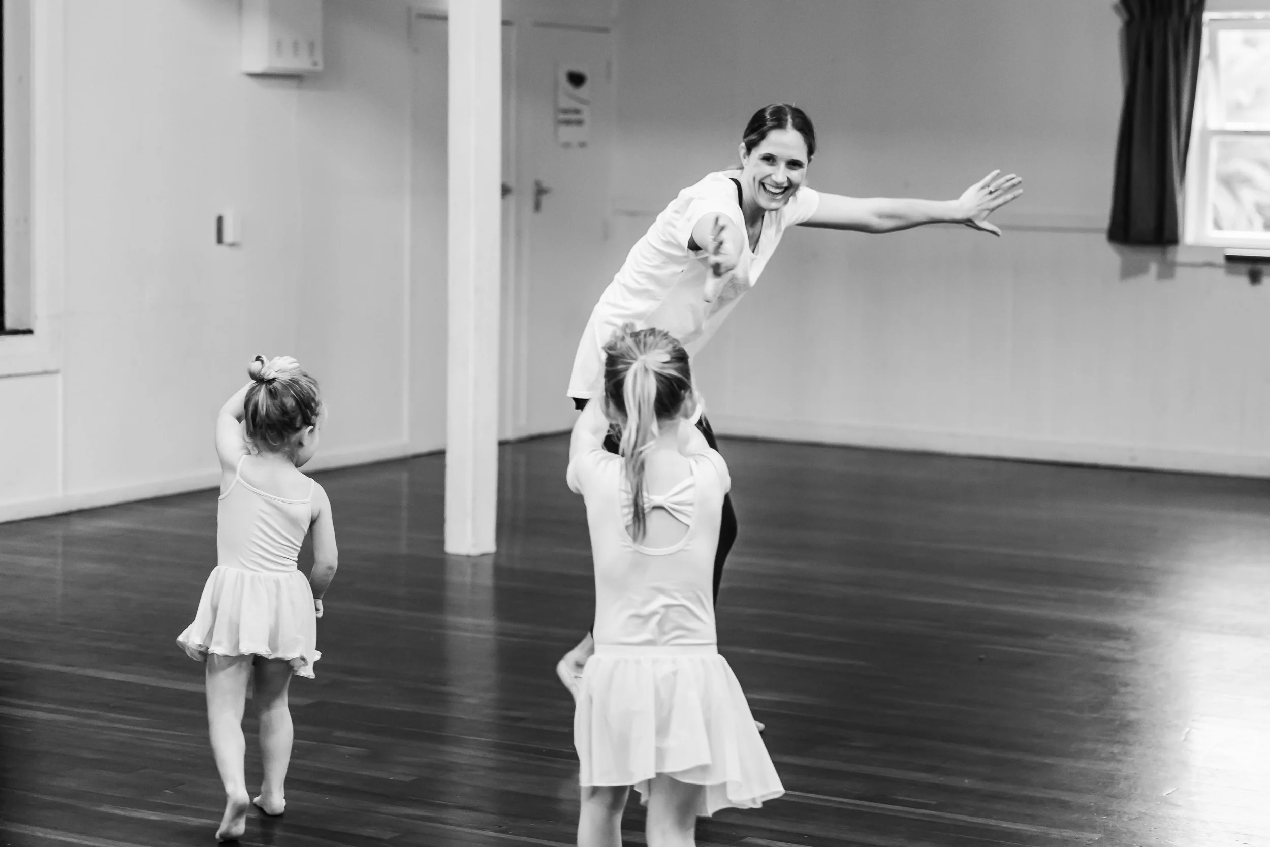 First Position Ballet Academy Director Jess in action with arms out wide and smiling