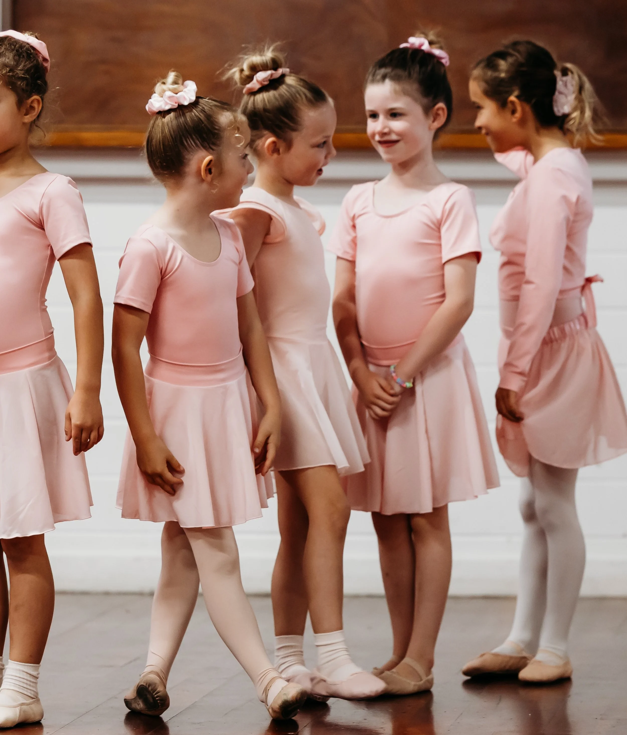 Group of young ballet dancers standing casually and chatting