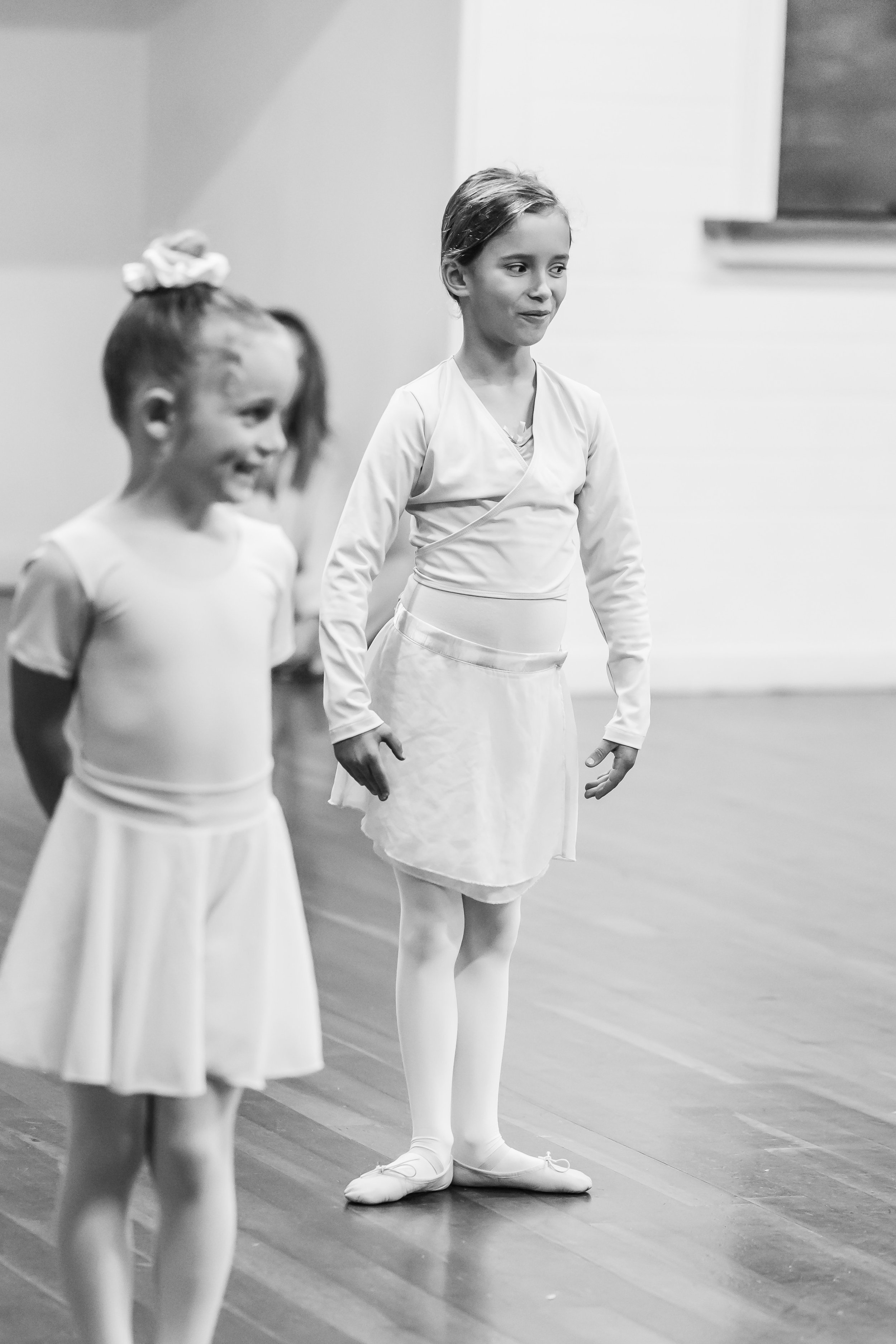 Two dancers standing ready to dance one in first position turned out and one in parallel