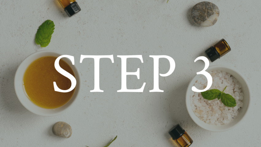 An overhead view of a spa or wellness setup with bowls of oil and salt, surrounded by small bottles of essential oils, stones, and mint leaves, overlaid with the text 'STEP 3'.