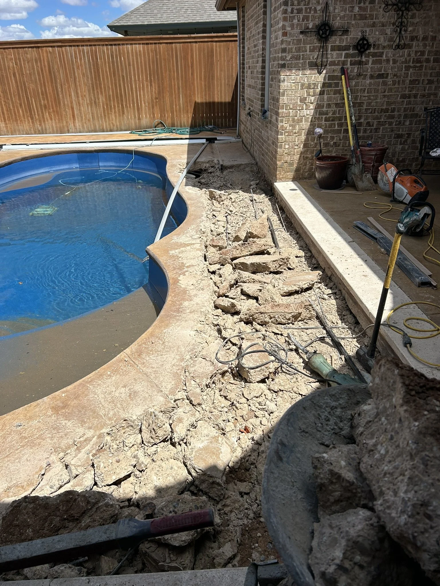 Preparing and grading dirt for an inground pool backfill project.