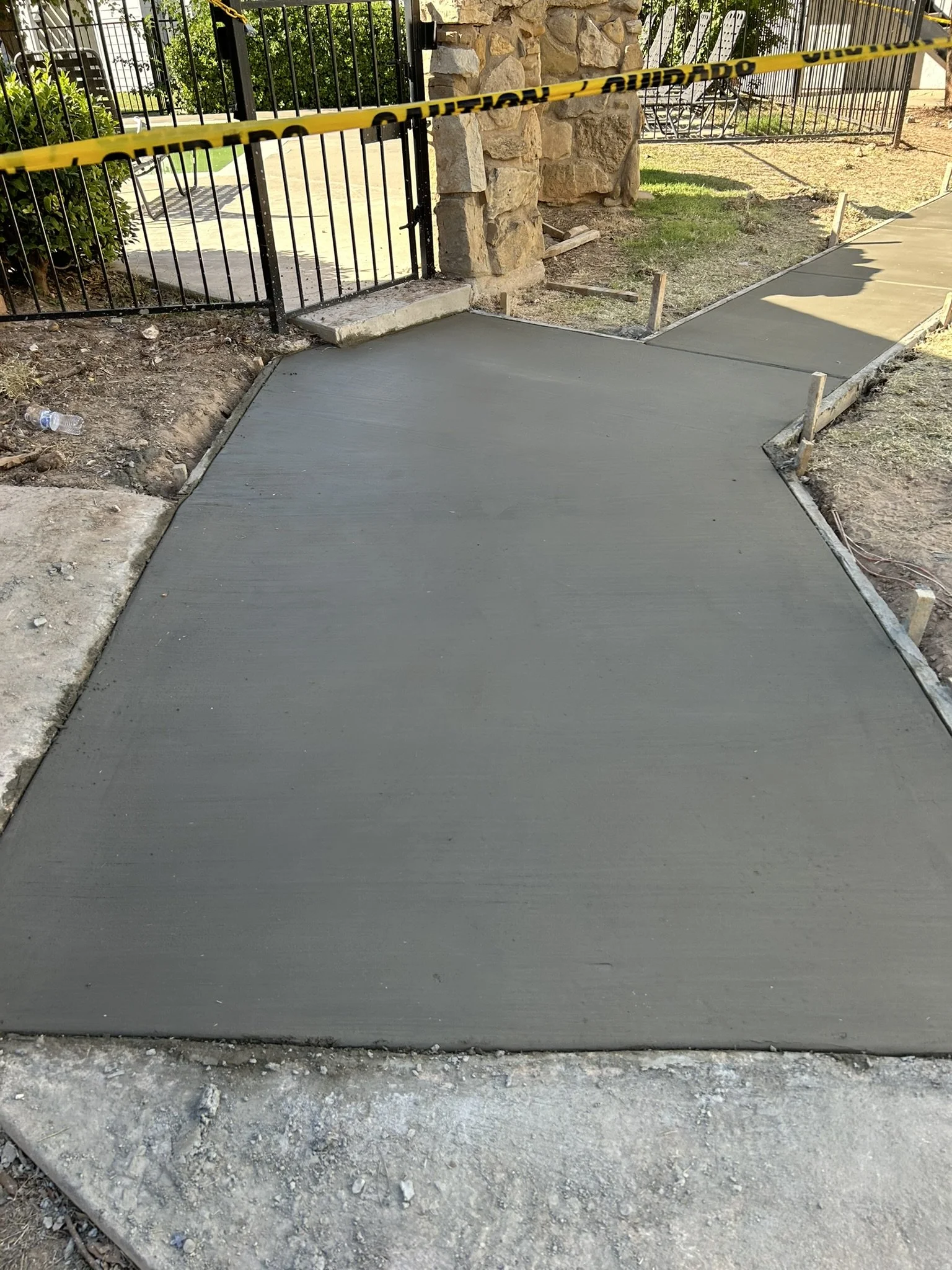 Freshly poured and finished smooth concrete sidewalk entry.