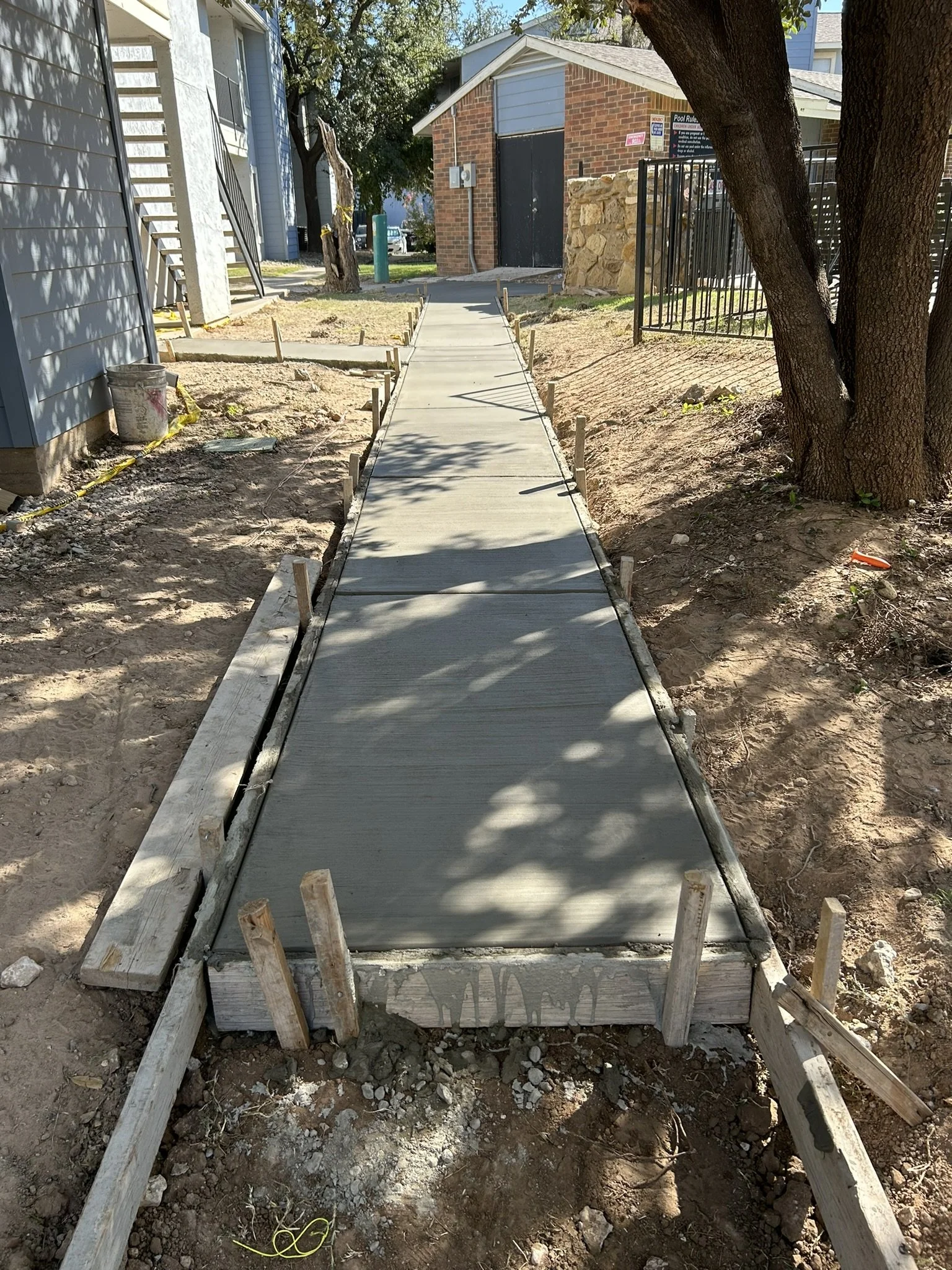 Forming and preparing a new concrete walkway path in Lubbock, Texas.