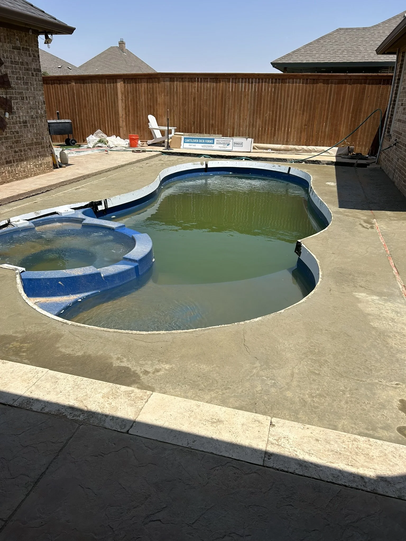 Pouring and leveling fresh concrete for a residential pool deck remodel.