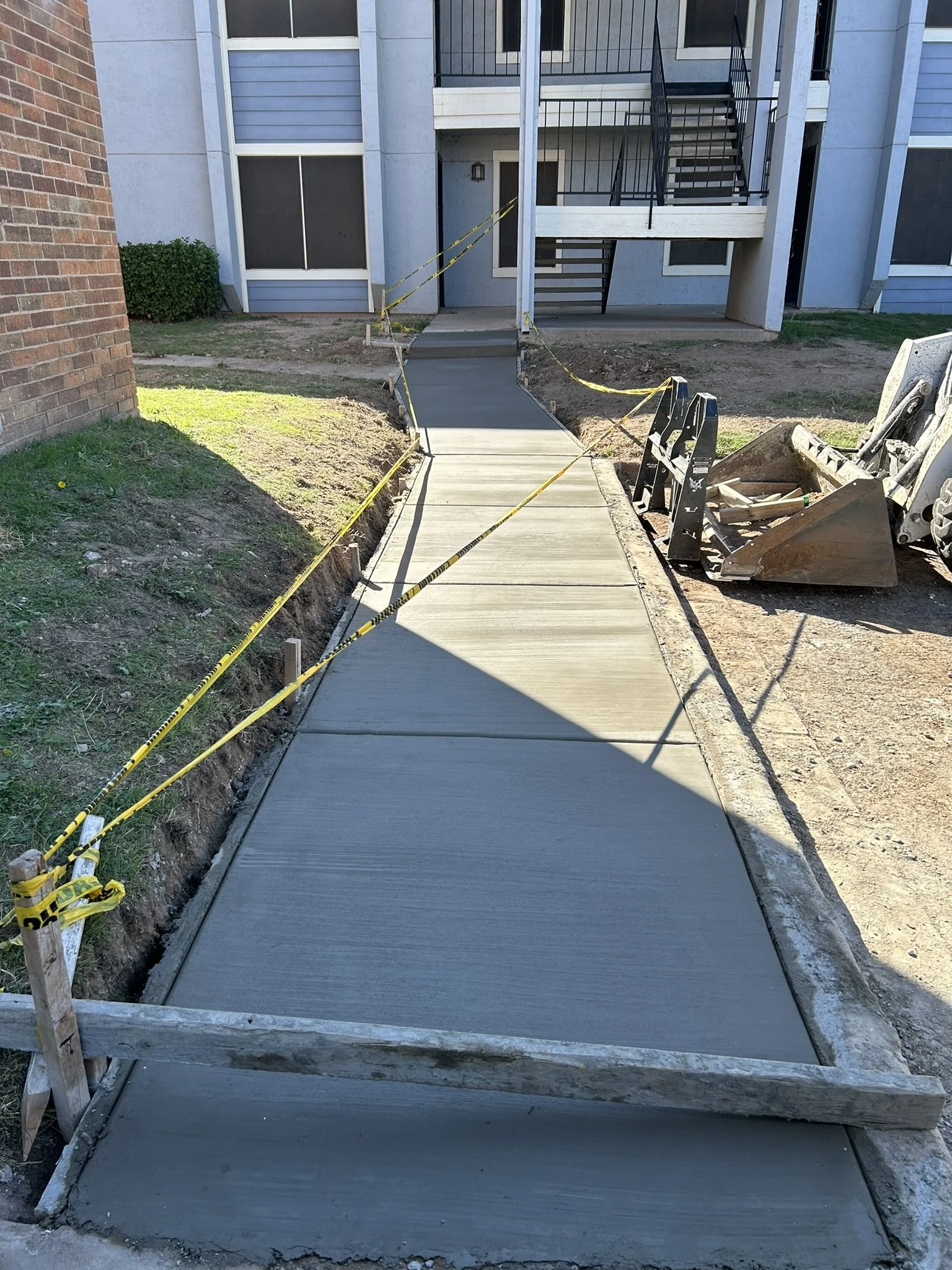 Custom concrete sidewalk installation for residential property.