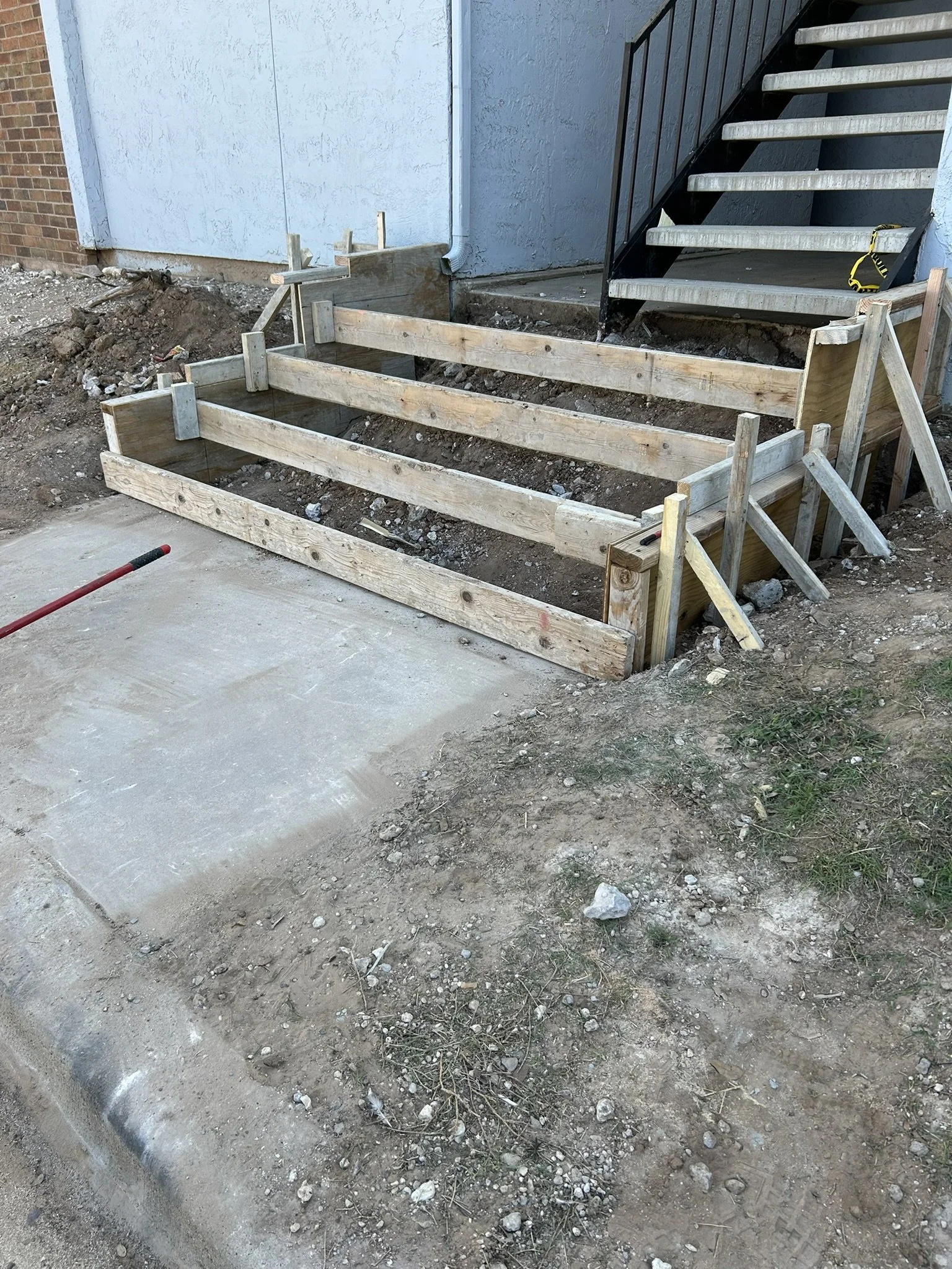 Setting up wooden formwork and framing for custom concrete steps.