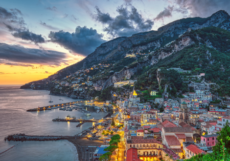 A villa glows with light as the sunsets over the bay. 