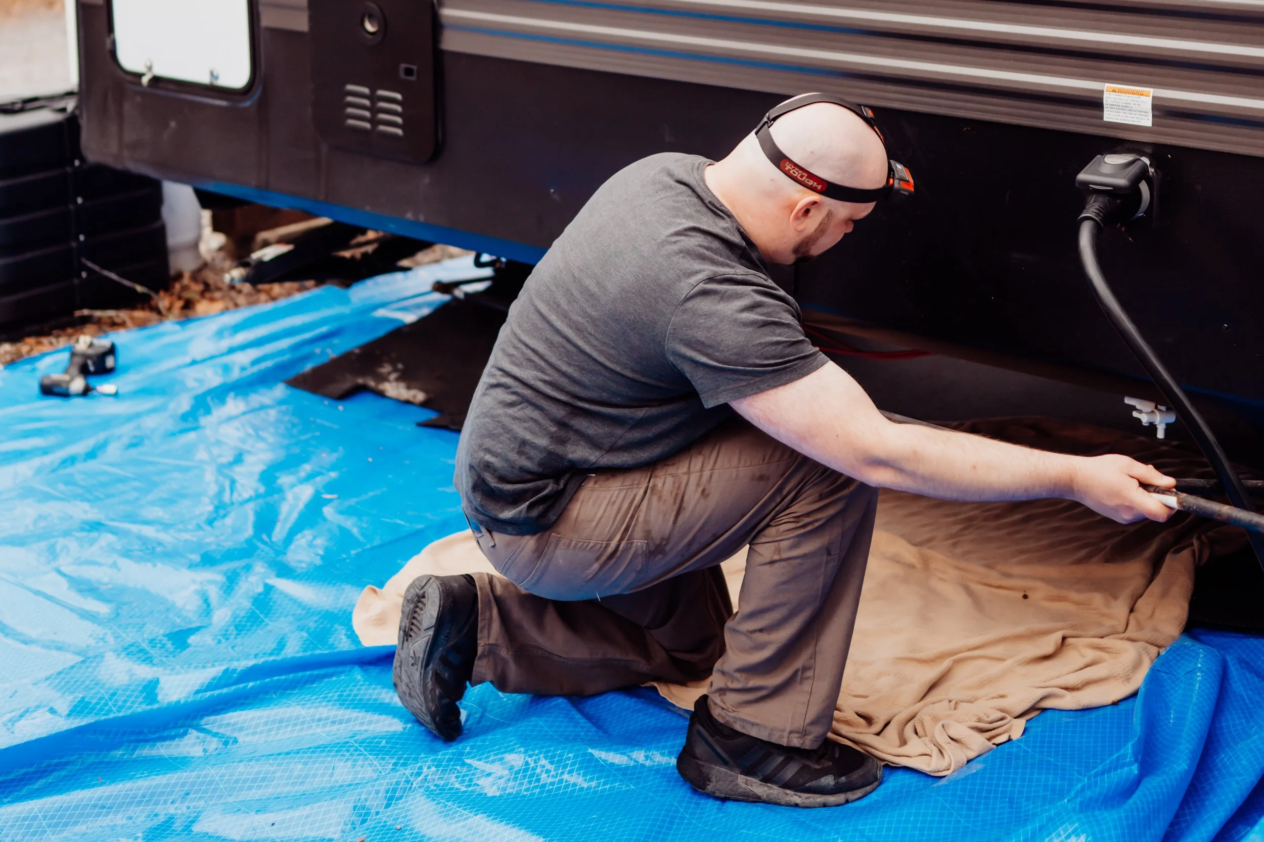 Chris working on a propane line on a camper