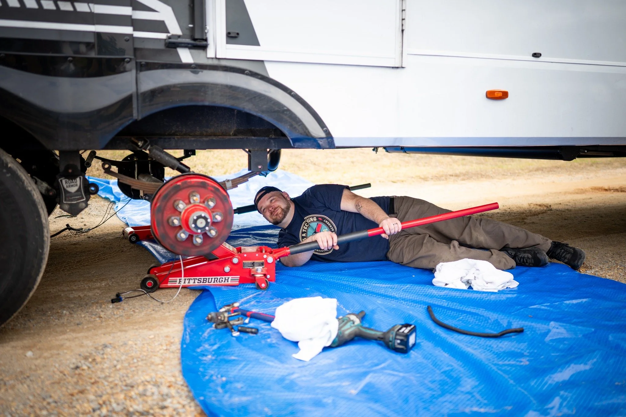 Chris using a jack on a camper axle
