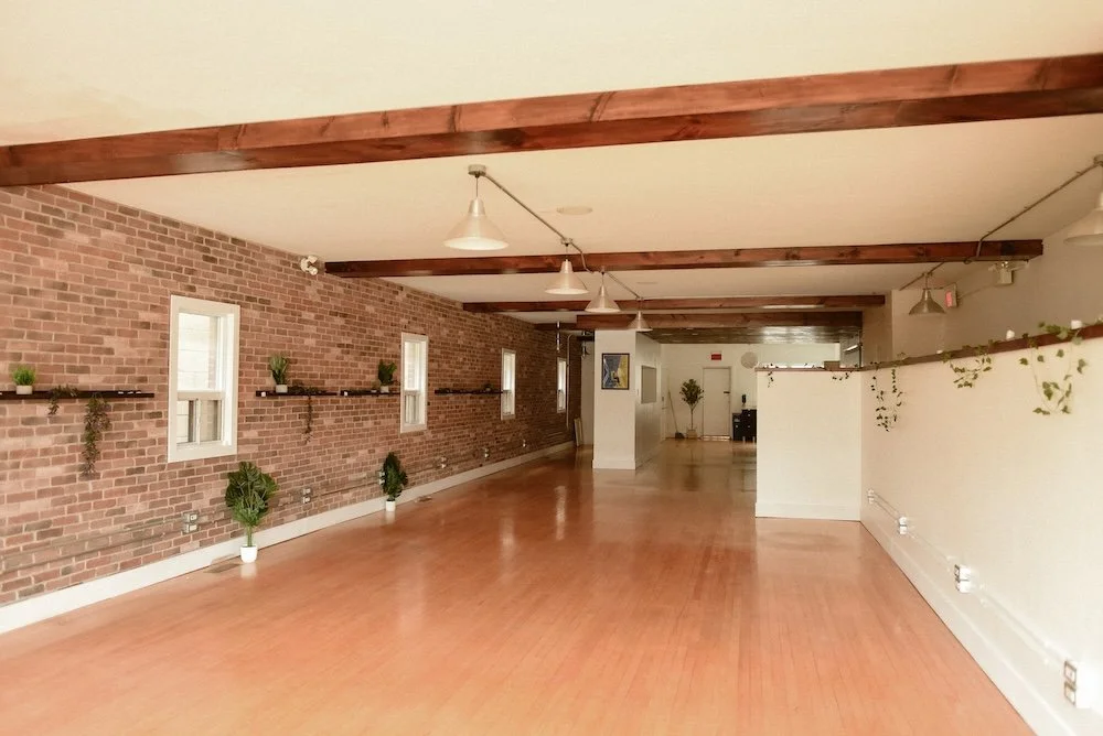 Long hallway shots of wellness studio with exposed brick wall.