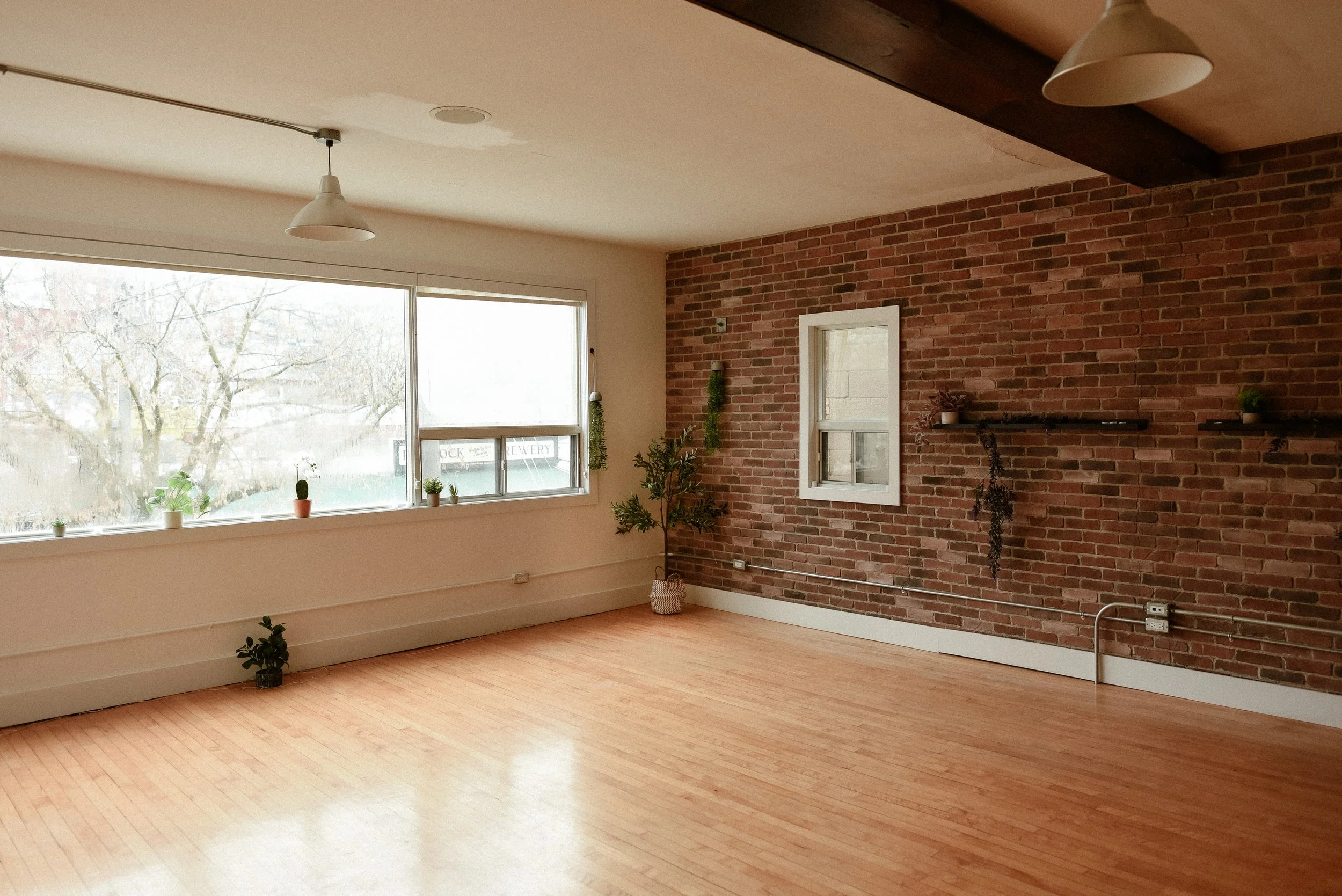 Wellness studio corner with larger window and exposed brick wall.
