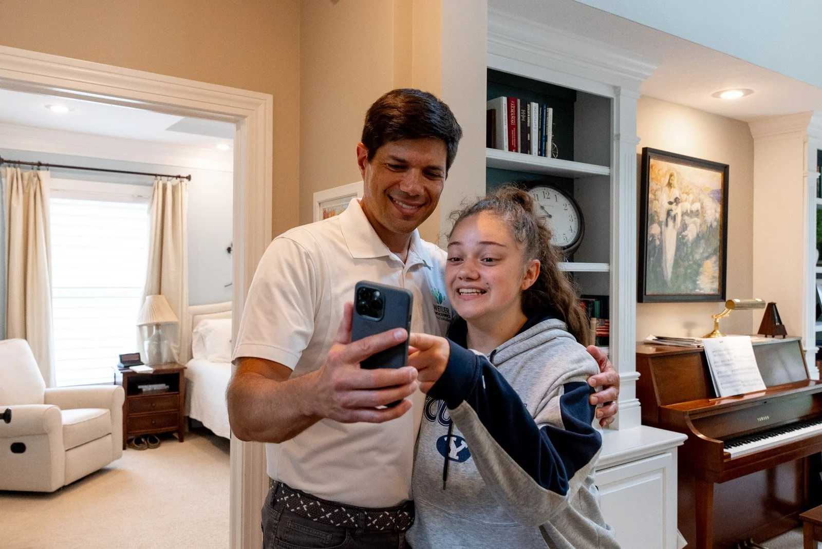 Two people looking at a phone together in a living room, smiling.