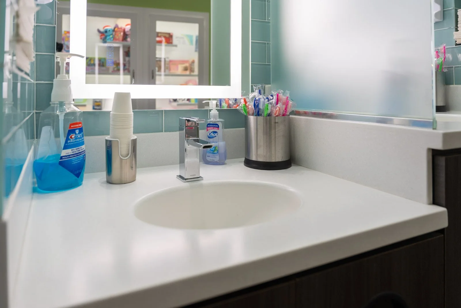 An oral care station stocked with toothbrushes, mouthwash, and rinse cups for patients at Weiler Orthodontics in Harrisonburg, VA