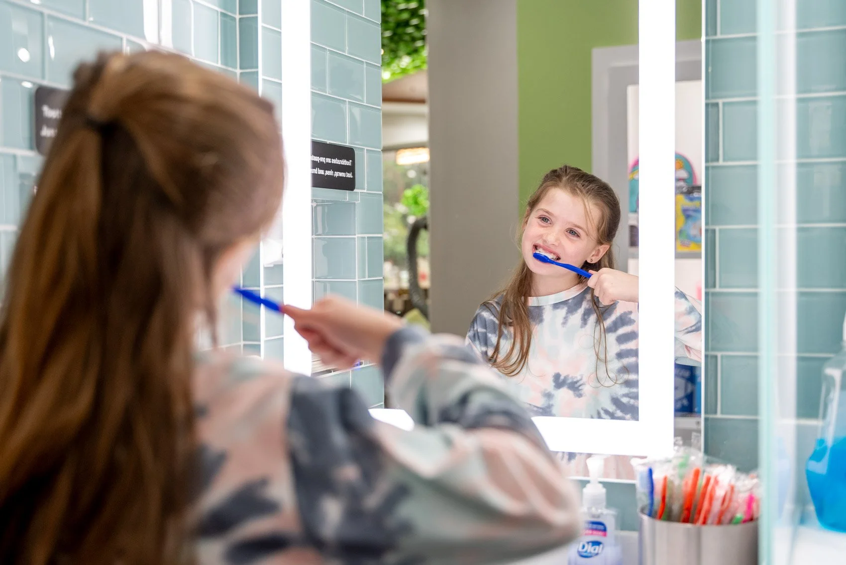 A young patient with braces brushes her teeth as part of her morning orthodontic routine at Weiler Orthodontics
