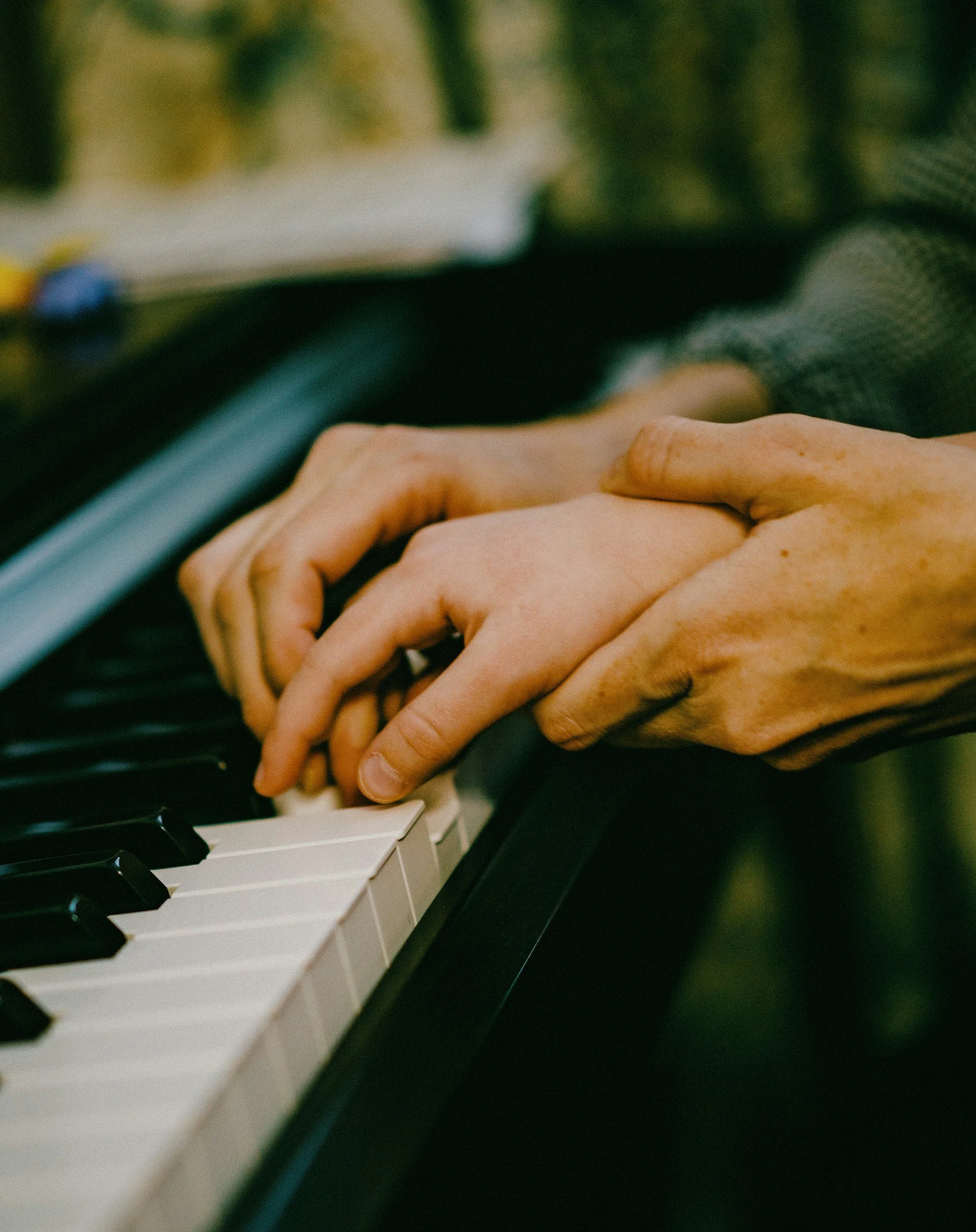 Close-up of hands playing a piano keyboard.