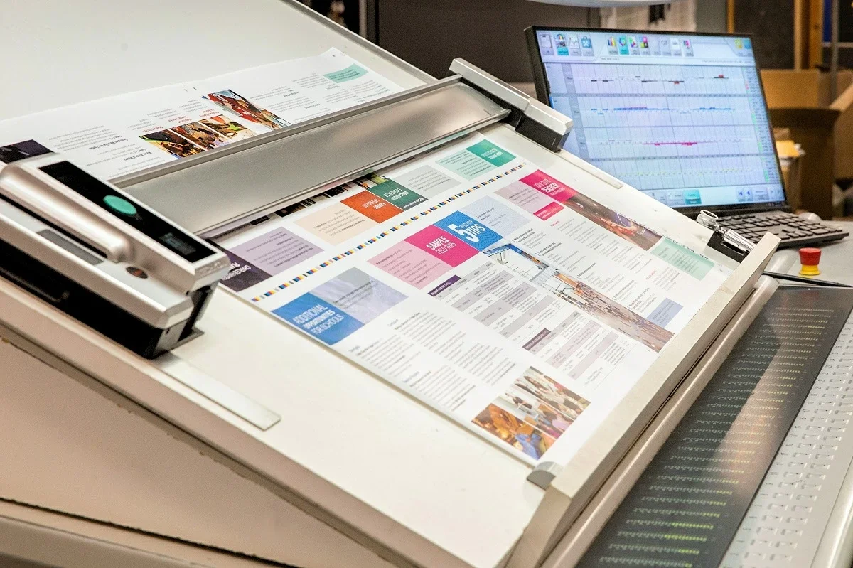 Spectrophotometer measuring color on printed press sheet during calibration for consistent print quality