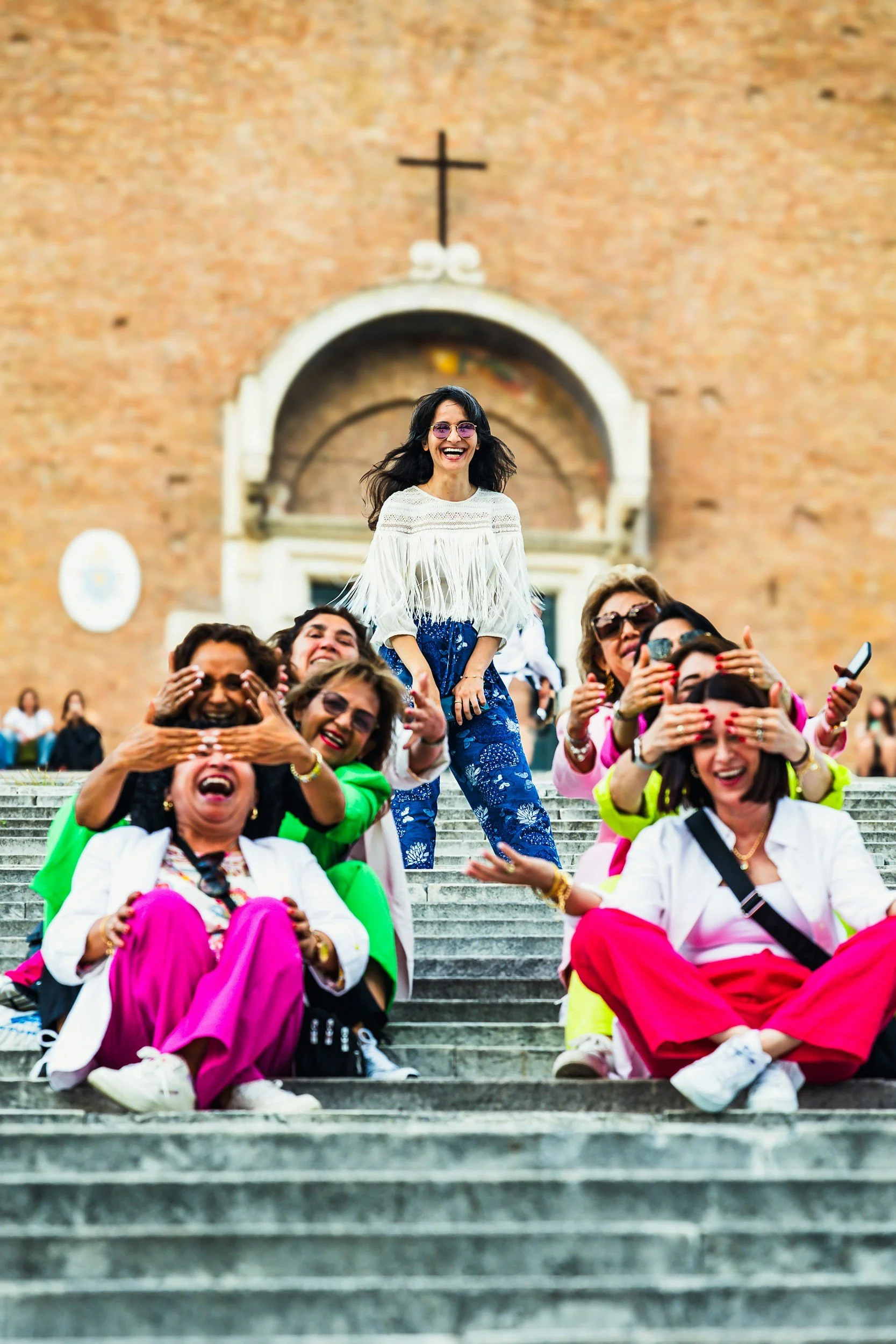 Multigenerational group of women sitting on steps of church building