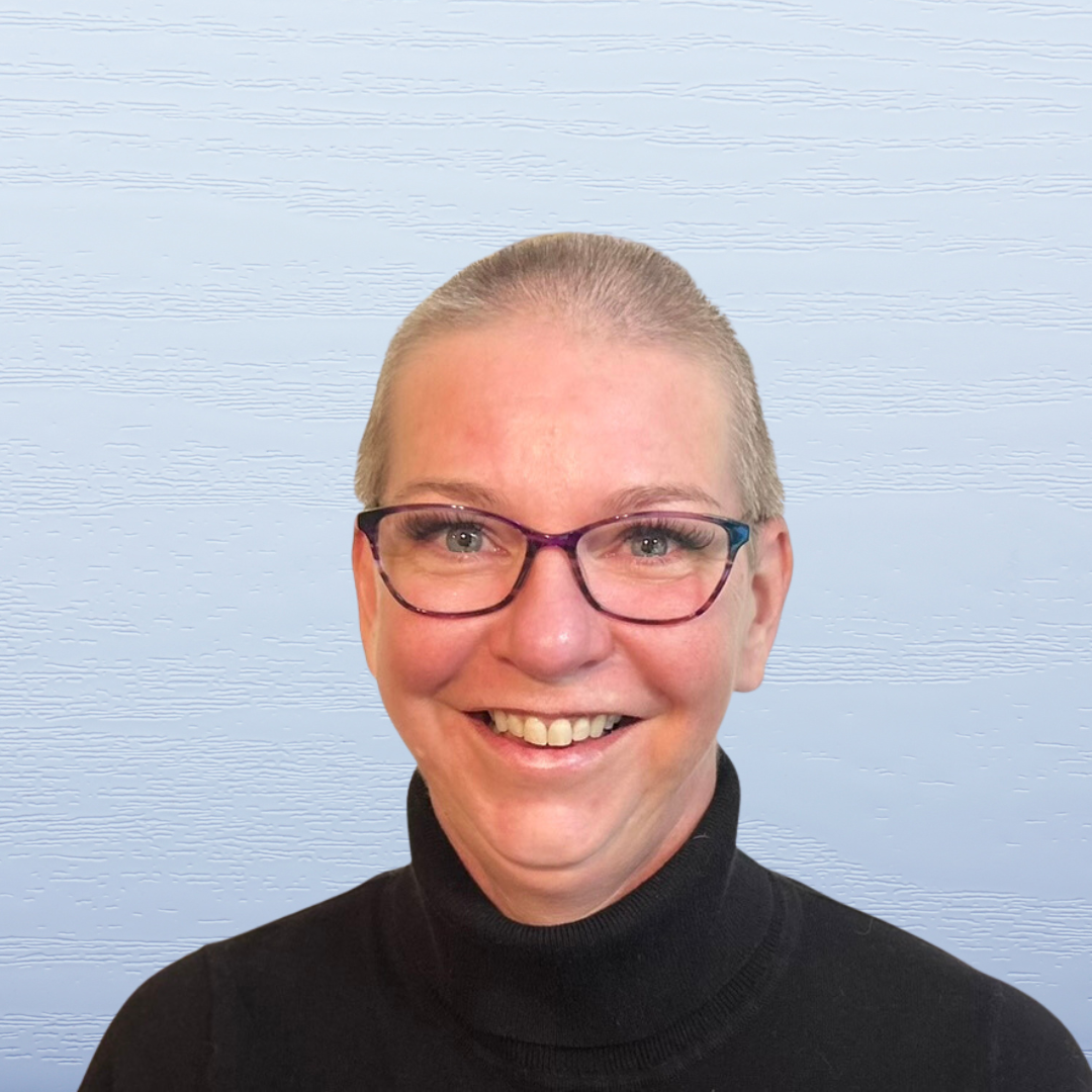 Smiling woman with short hair, glasses, and a black turtleneck against a light blue textured background.