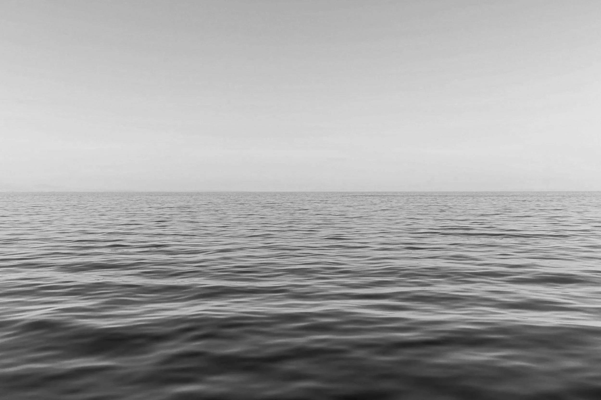 Calm ocean with gentle waves and a clear sky in the background