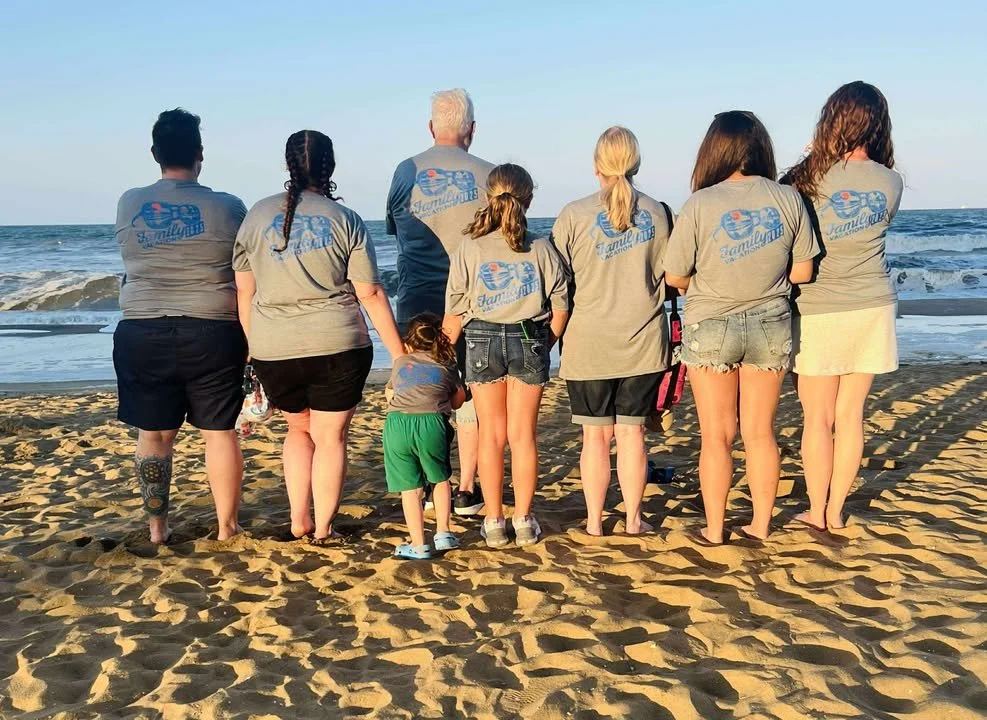 Image of a group of people on the beach with matching custom shirts
