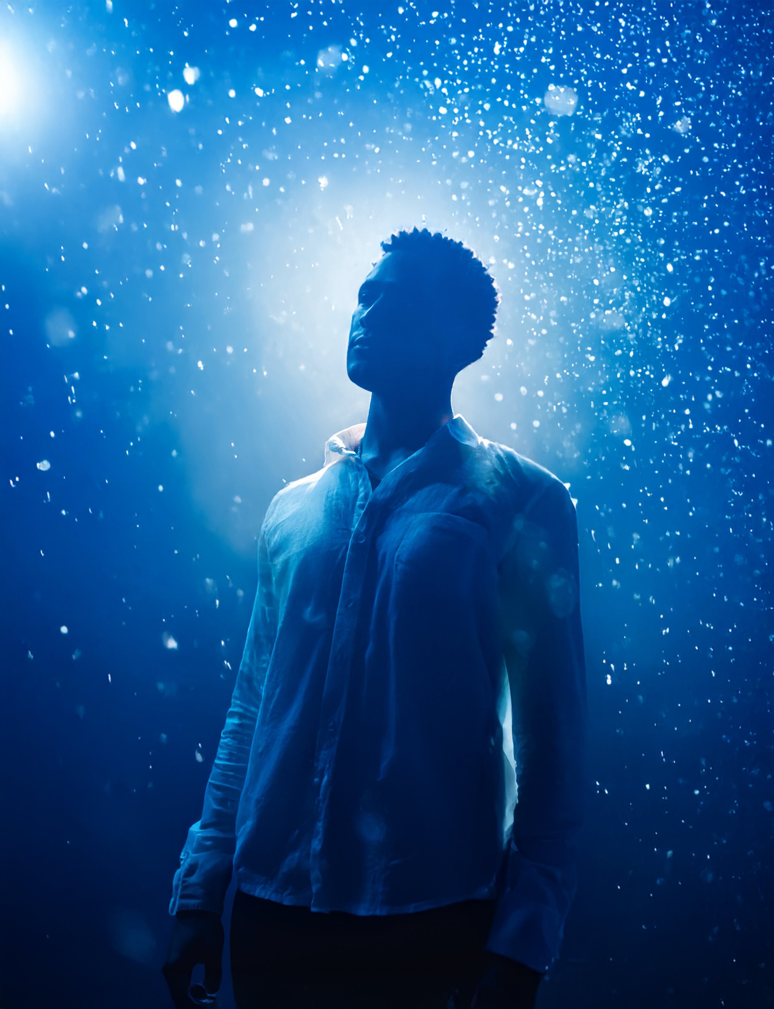 SE4NKENNEDY, independent recording artist and founder of LO$T ONE$ Records, photographed in a dark space with blue backlighting.