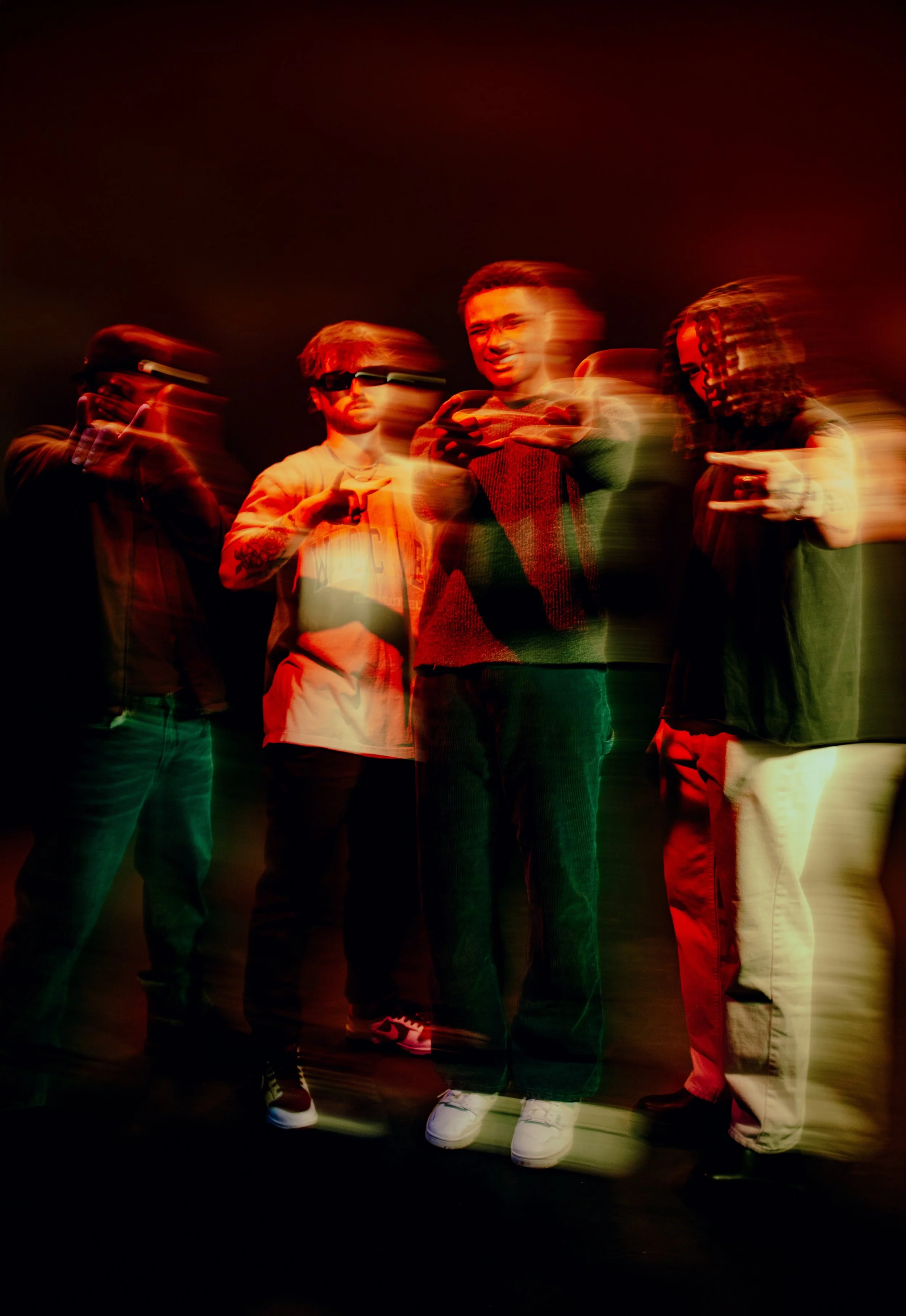 Artists from LO$T ONE$ Records standing together in a studio setting, captured with motion blur to reflect creative energy and collaboration.