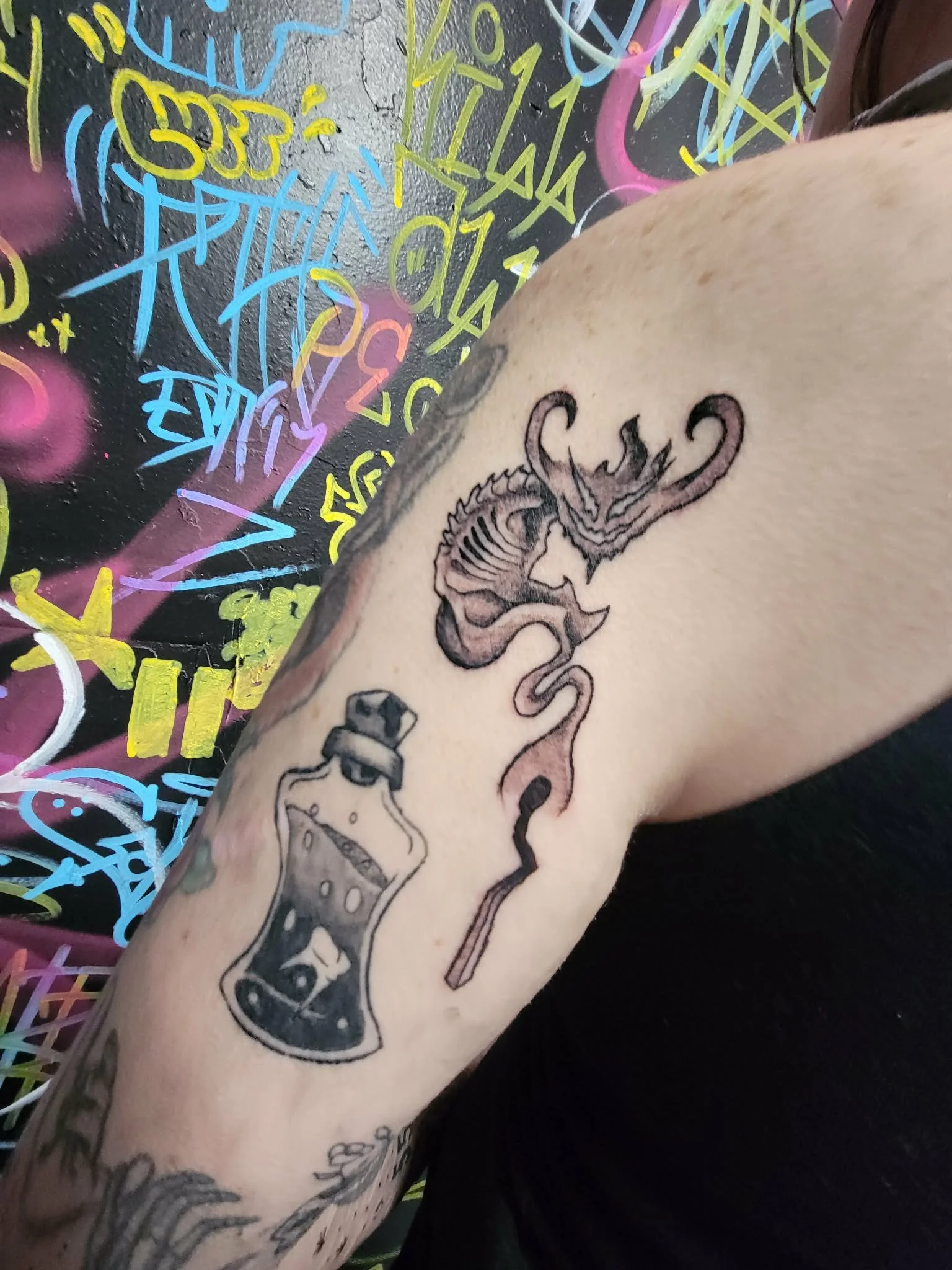 demon coming from a match in stipple style on upper arm