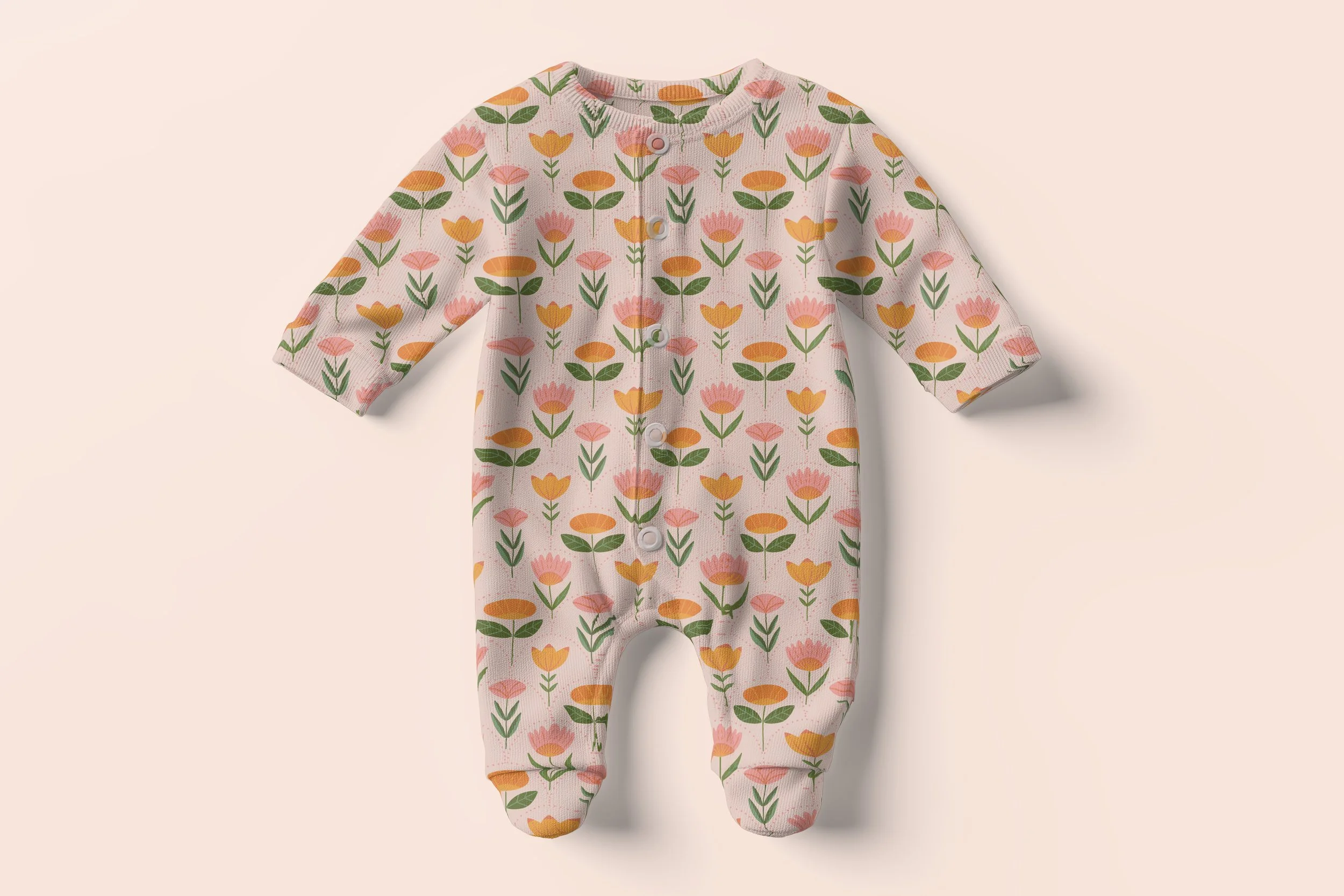 Pink baby sleeper with a floral pattern of pink, orange, and yellow flowers with green leaves.