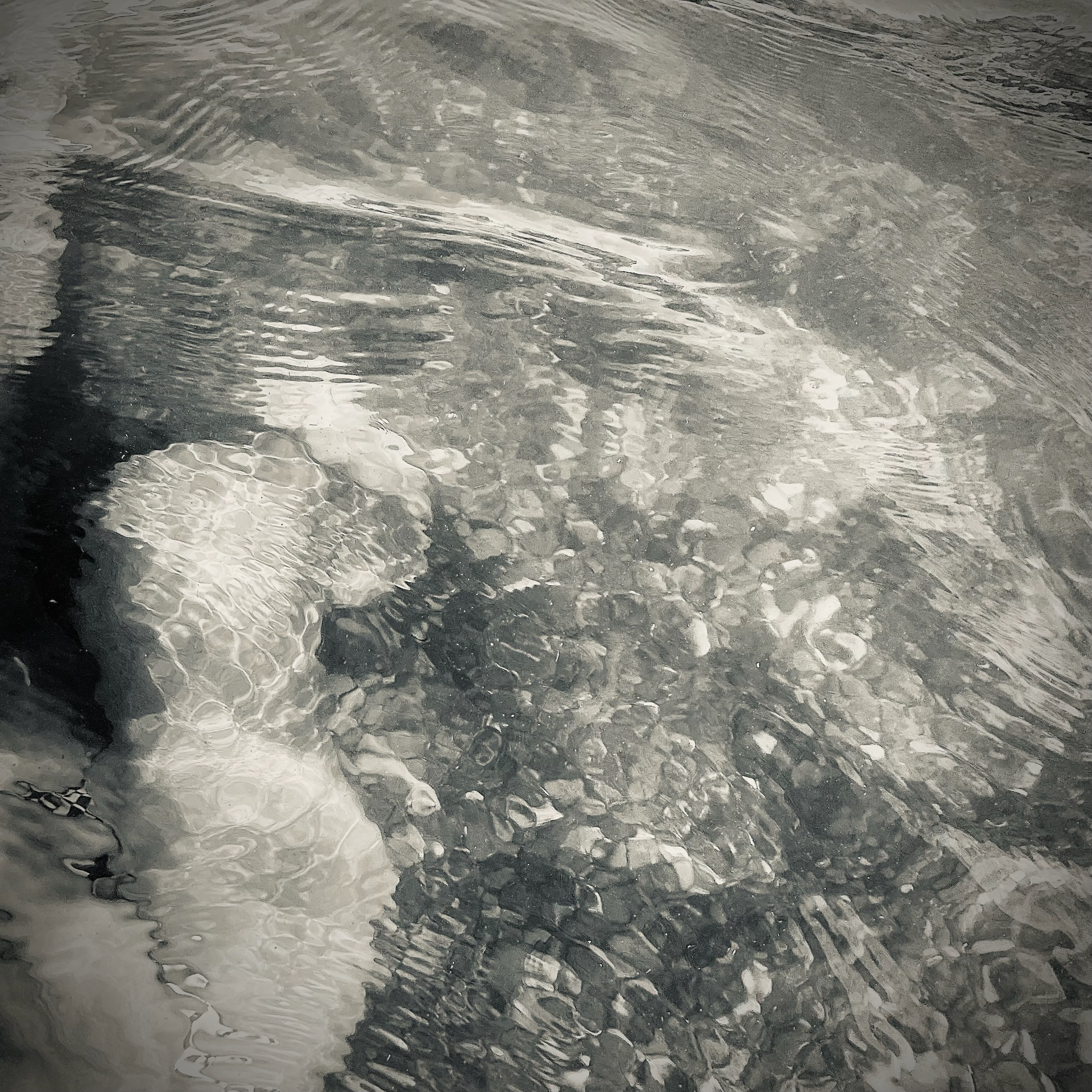 Captain e2 Brewster's body immersed in water — an abstract study in light and ripples, the fourth in this series.