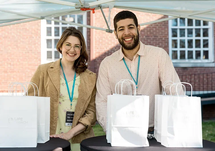 greeters smiling at the outdoor hospitality tent