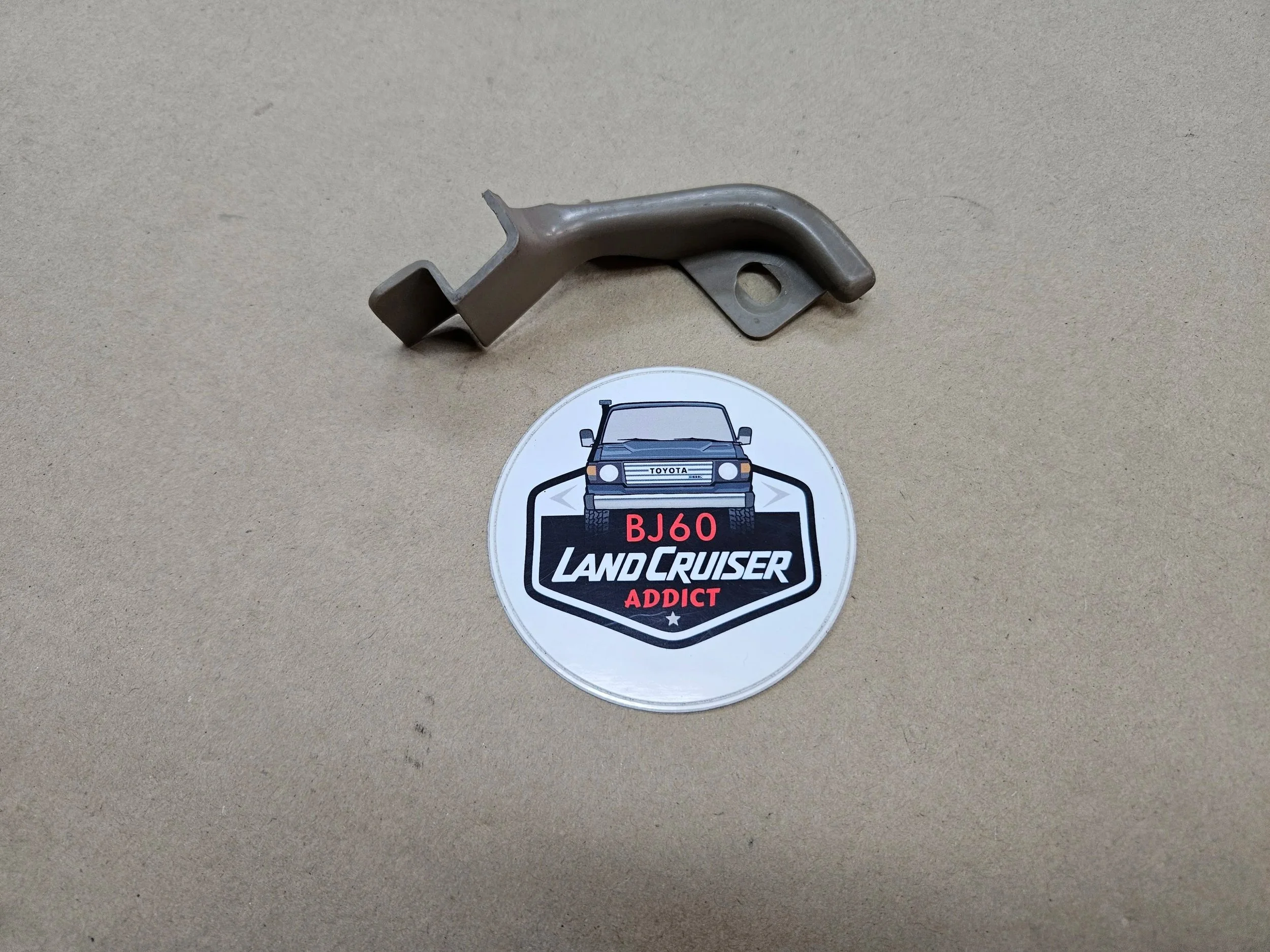 60-series Toyota Landcruiser kick panel cover bracket left side sepia brown.