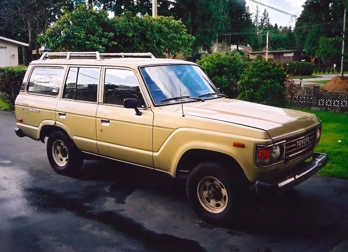 Beige 1981 BJ60 with factory white wheels parked on a driveway.