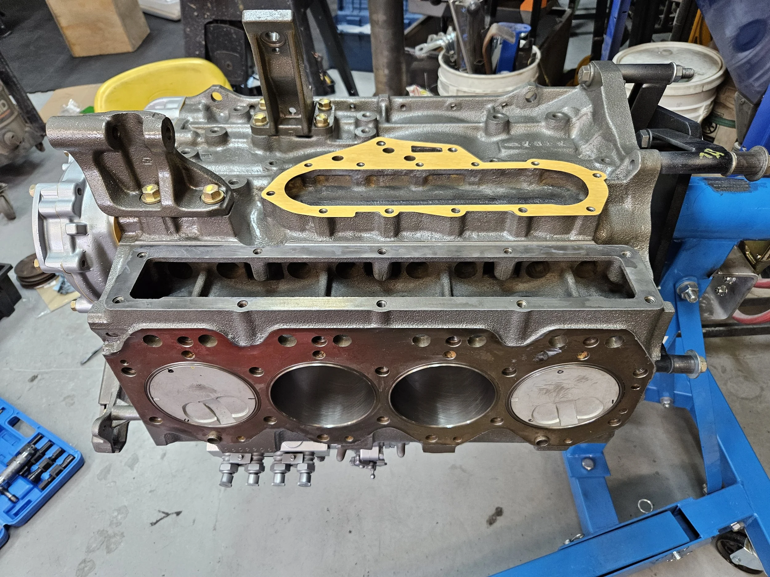 3B Toyota diesel engine on an engine stand with new pistons installed.