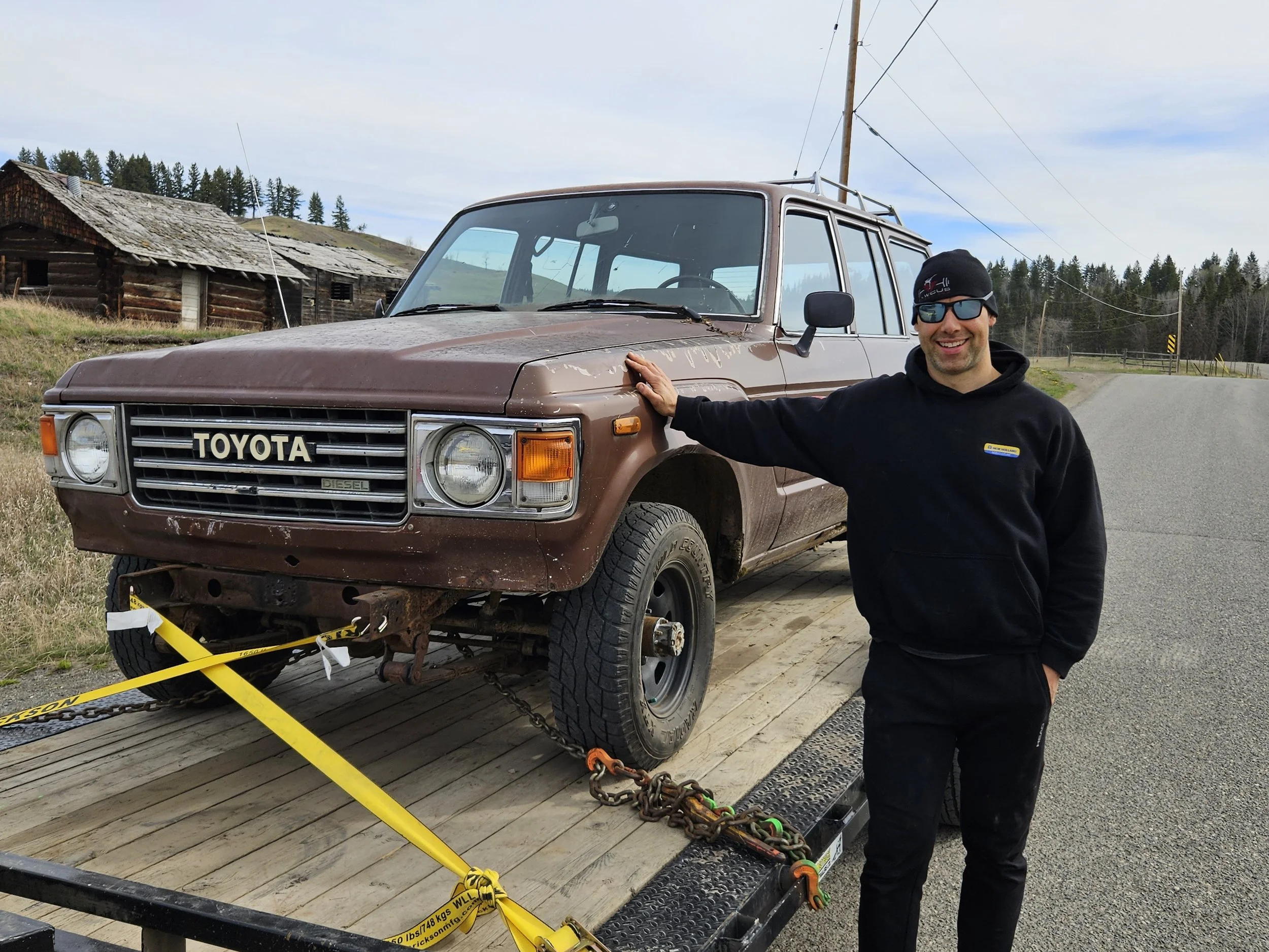BJ60 Toyota Landcruiser on a trailer with the owner standing beside it.