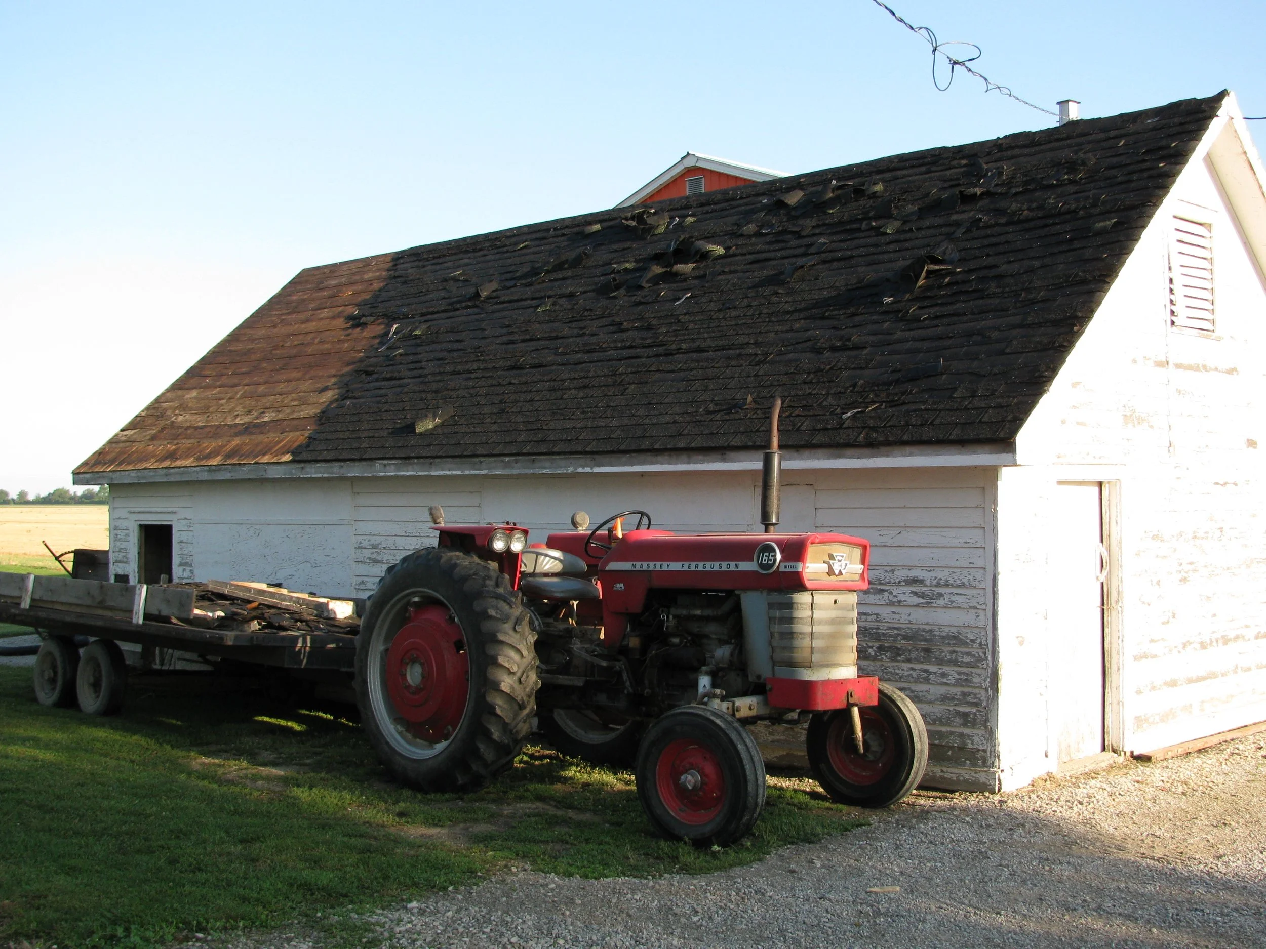 165 diesel Massey Ferguson parked beside an old chicken coop.