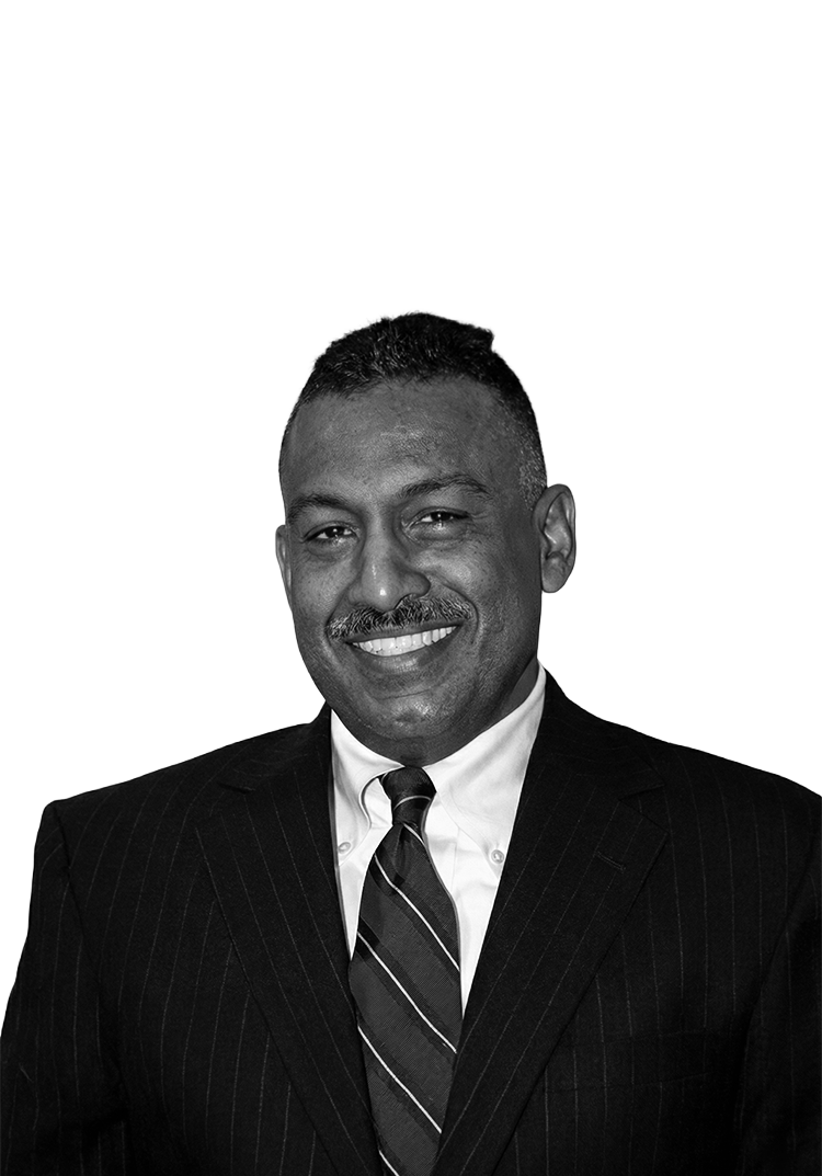 Black and white portrait of a man in a suit and tie, smiling.