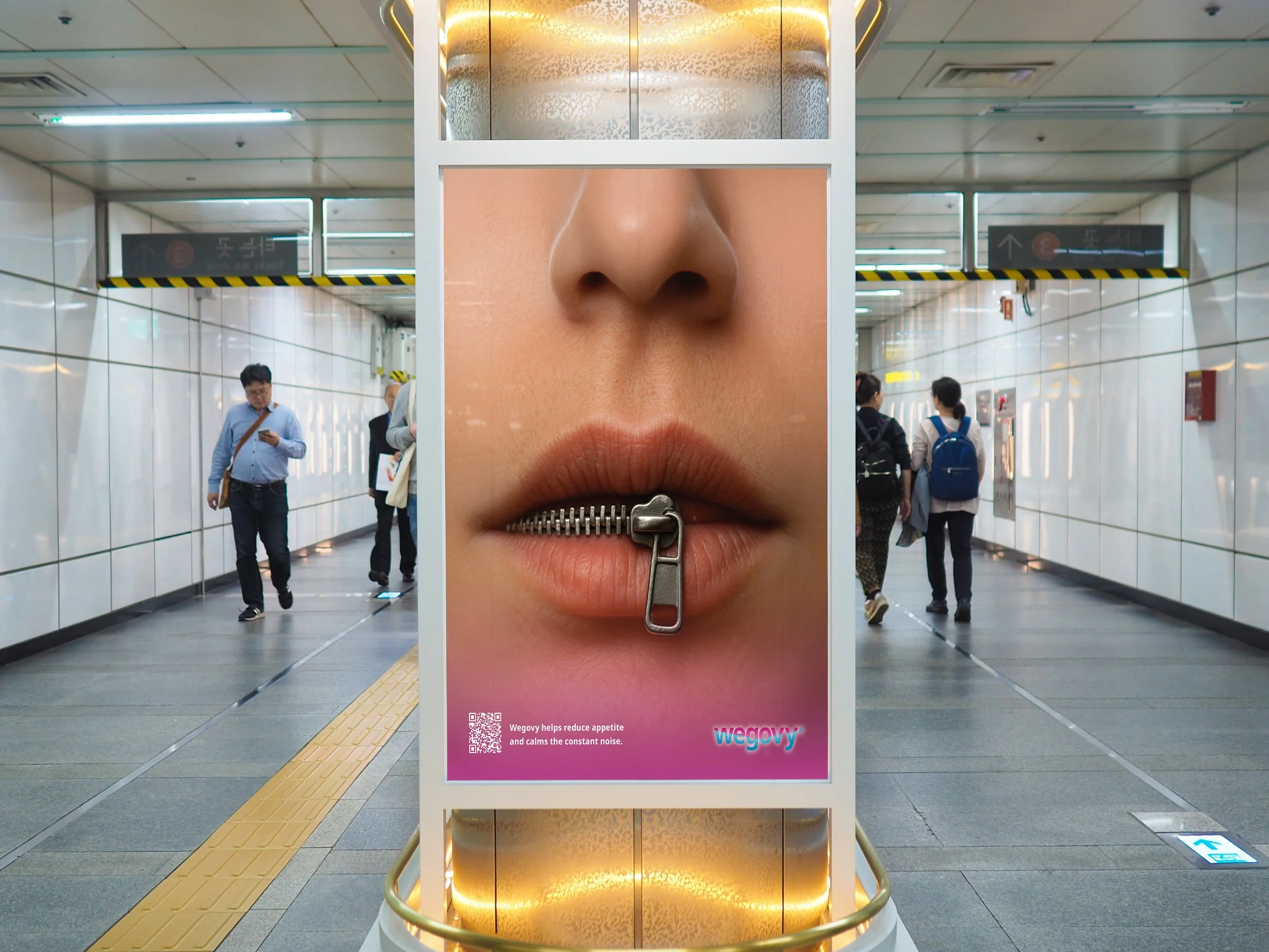 Advertising billboard in an underground subway station showing close-up of lips with a zipper as a mouth, promoting WEGOVY for reducing appetite and calming noise.