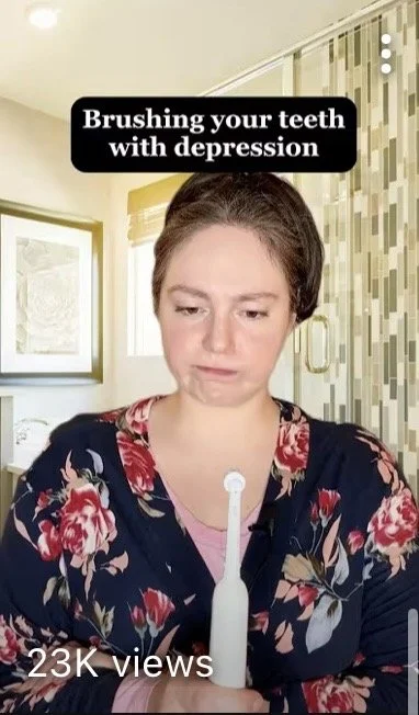 Woman with a digital depression screening device on her chest, looking down with a sad expression, in a home setting.