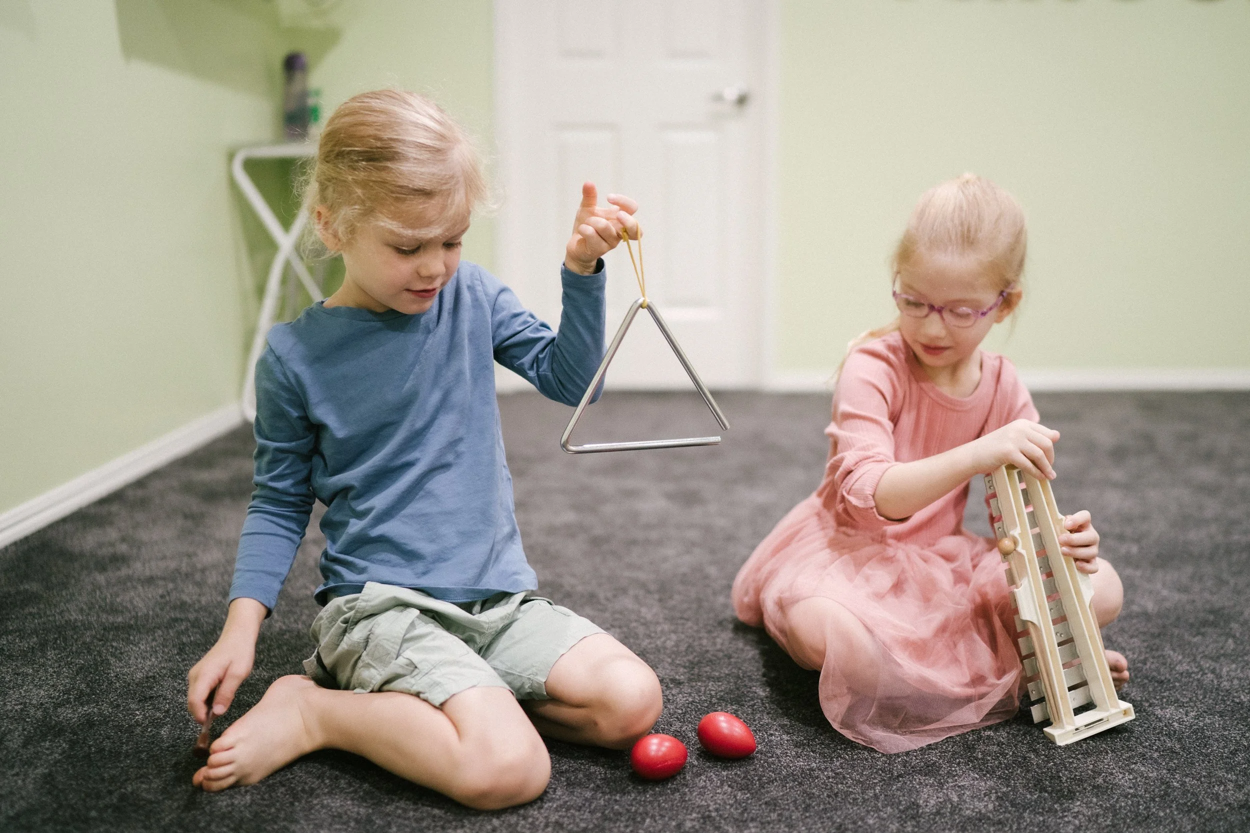 Two children playing and exploring different musical instruments at at Lesia's Music Place in Toowoomba.