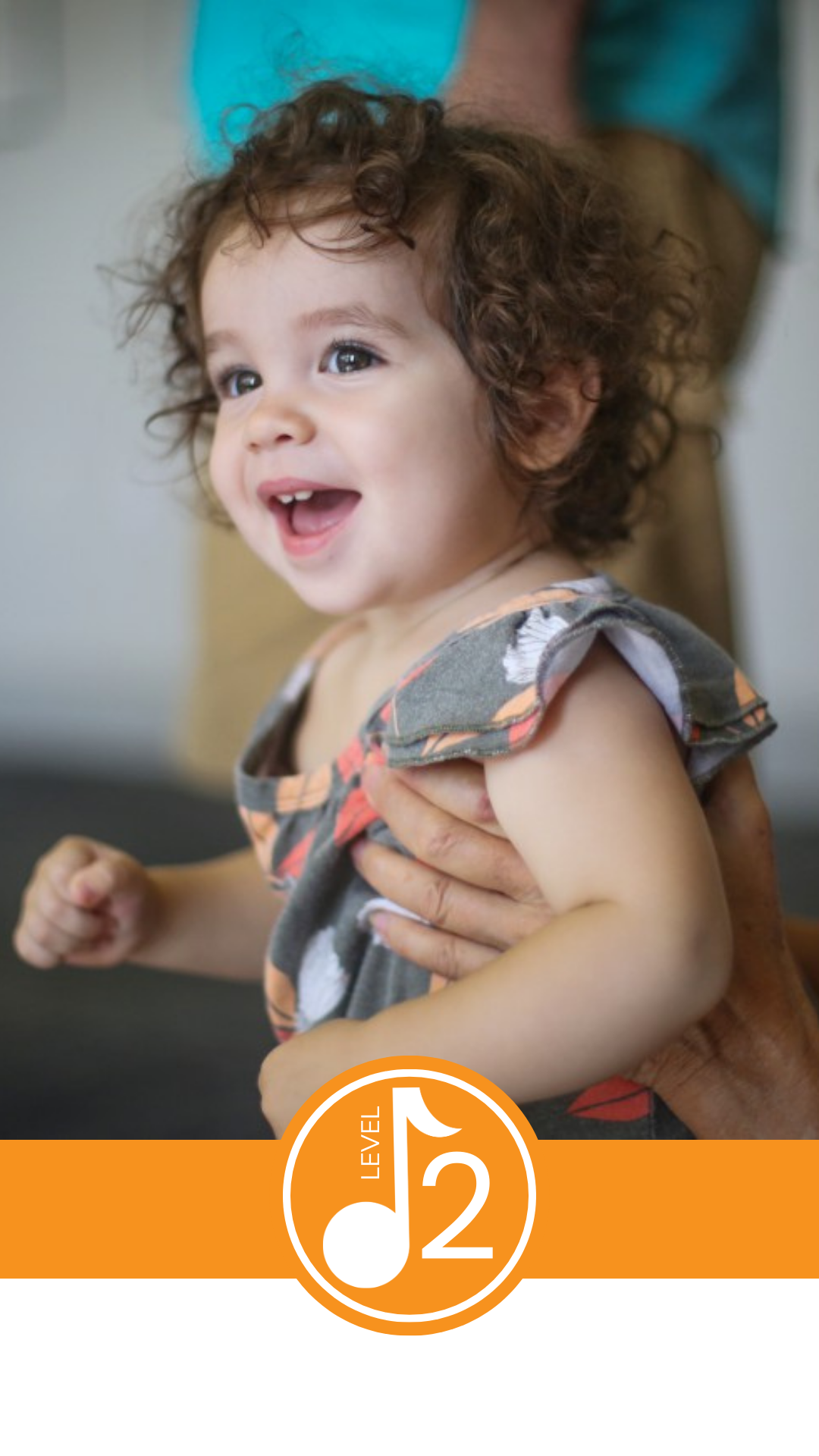 A smiling toddler having a good time in Leisa's music and movement class.