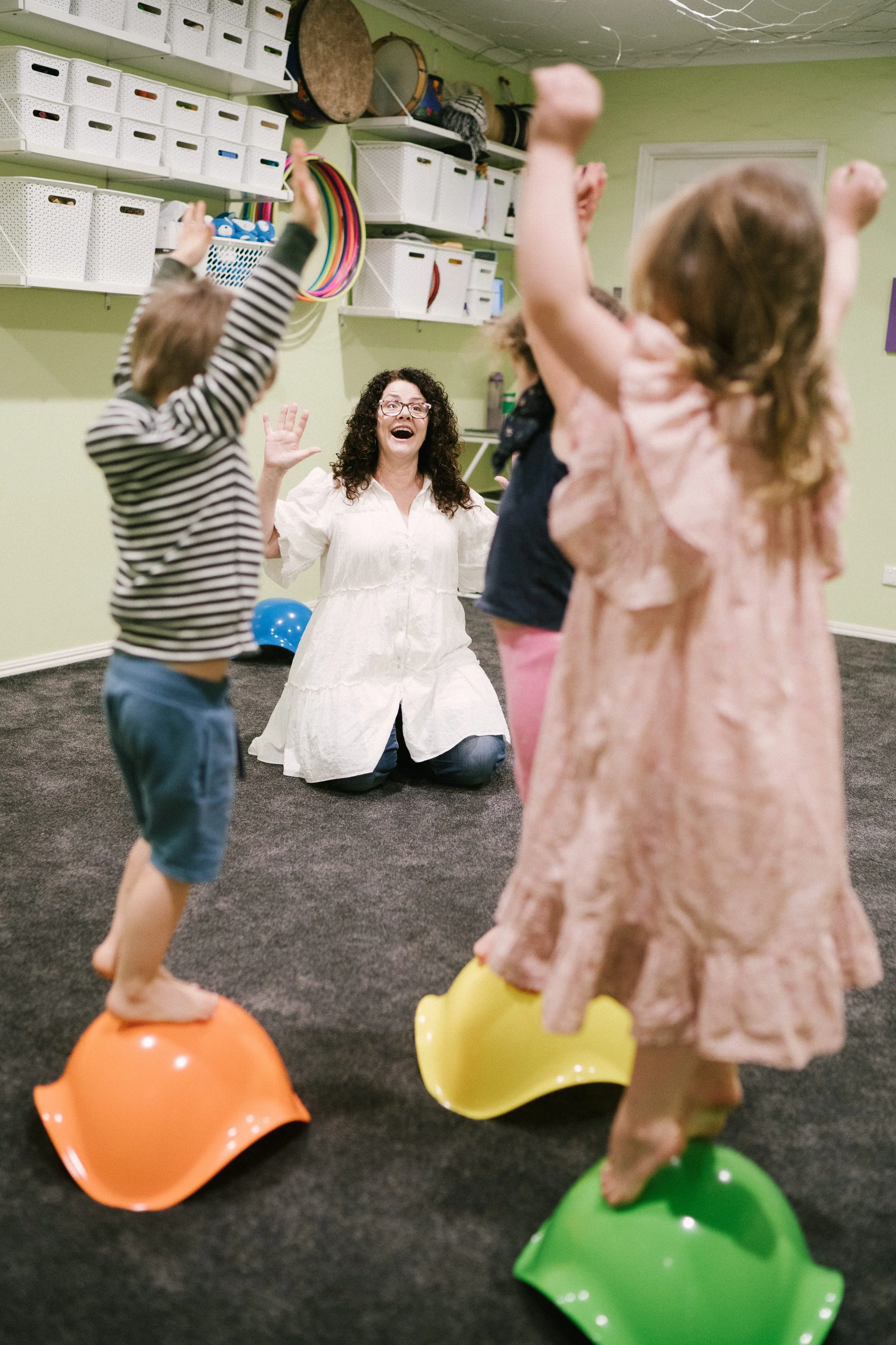 Leisa teaching dance, balance, coordination and music to young children during a music and movement class.