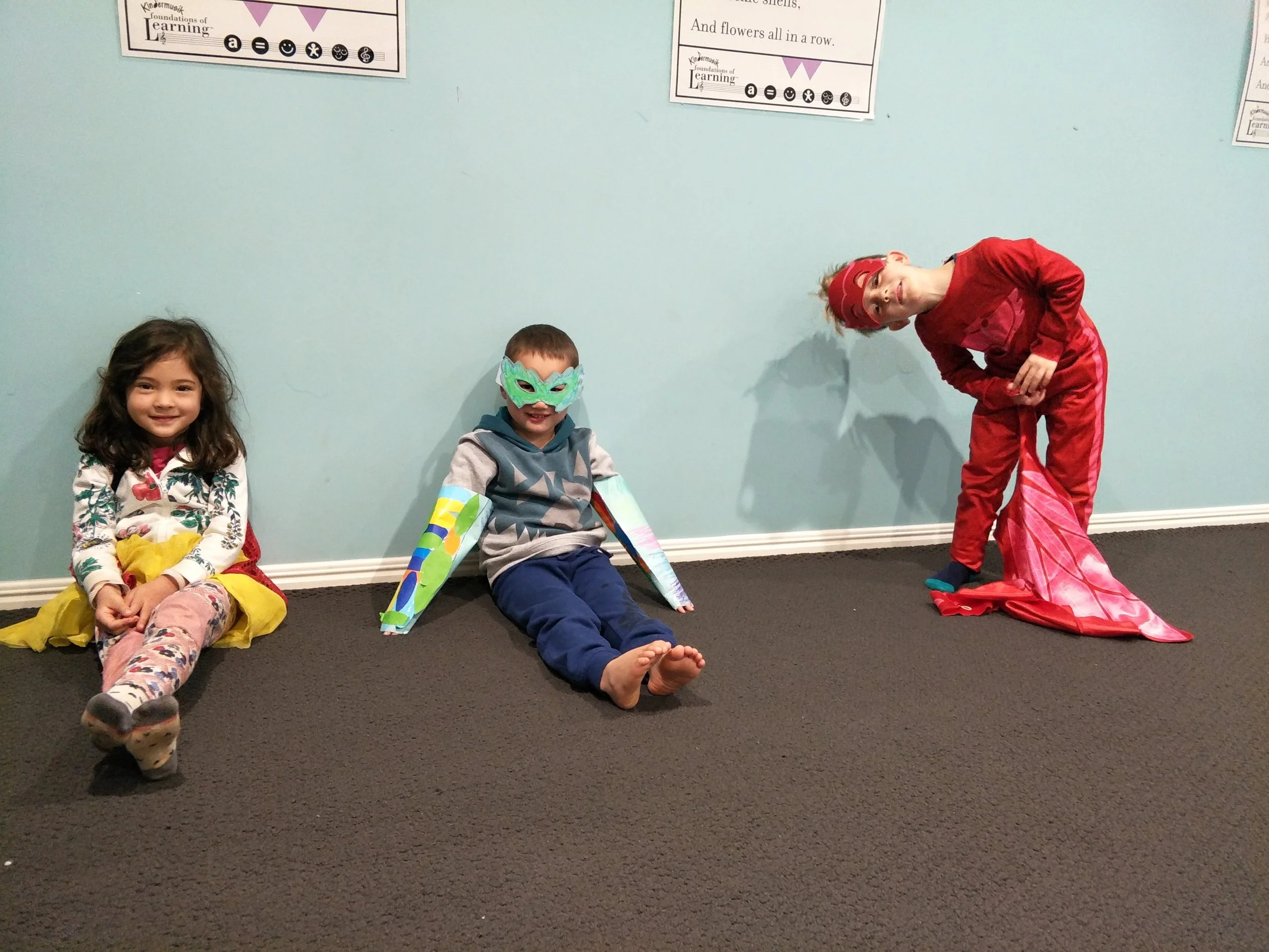 Young children playing dress ups and singing and dancing during a music and movement class.