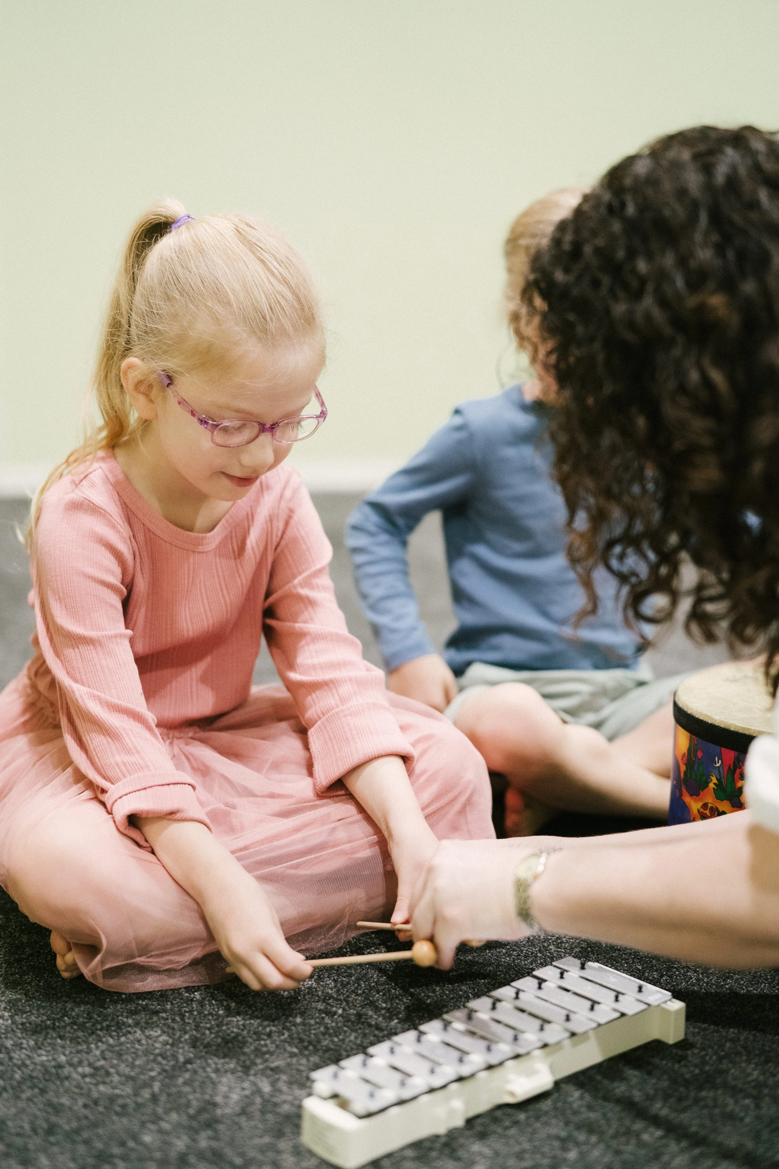 A young girl learning to play the xylophone at Leisa's Music Place during a Kindermusik class.