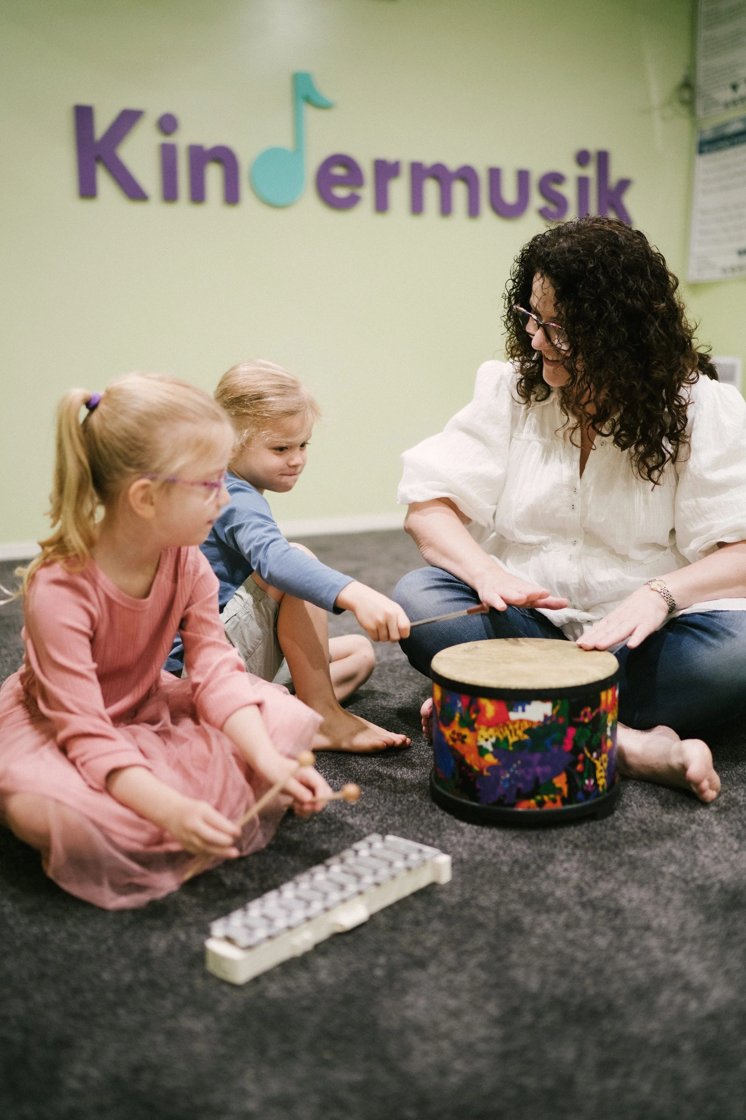 	
Leisa teaching two young girls to play the drums and xylophone at Lesia's Music Place in Toowoomba.